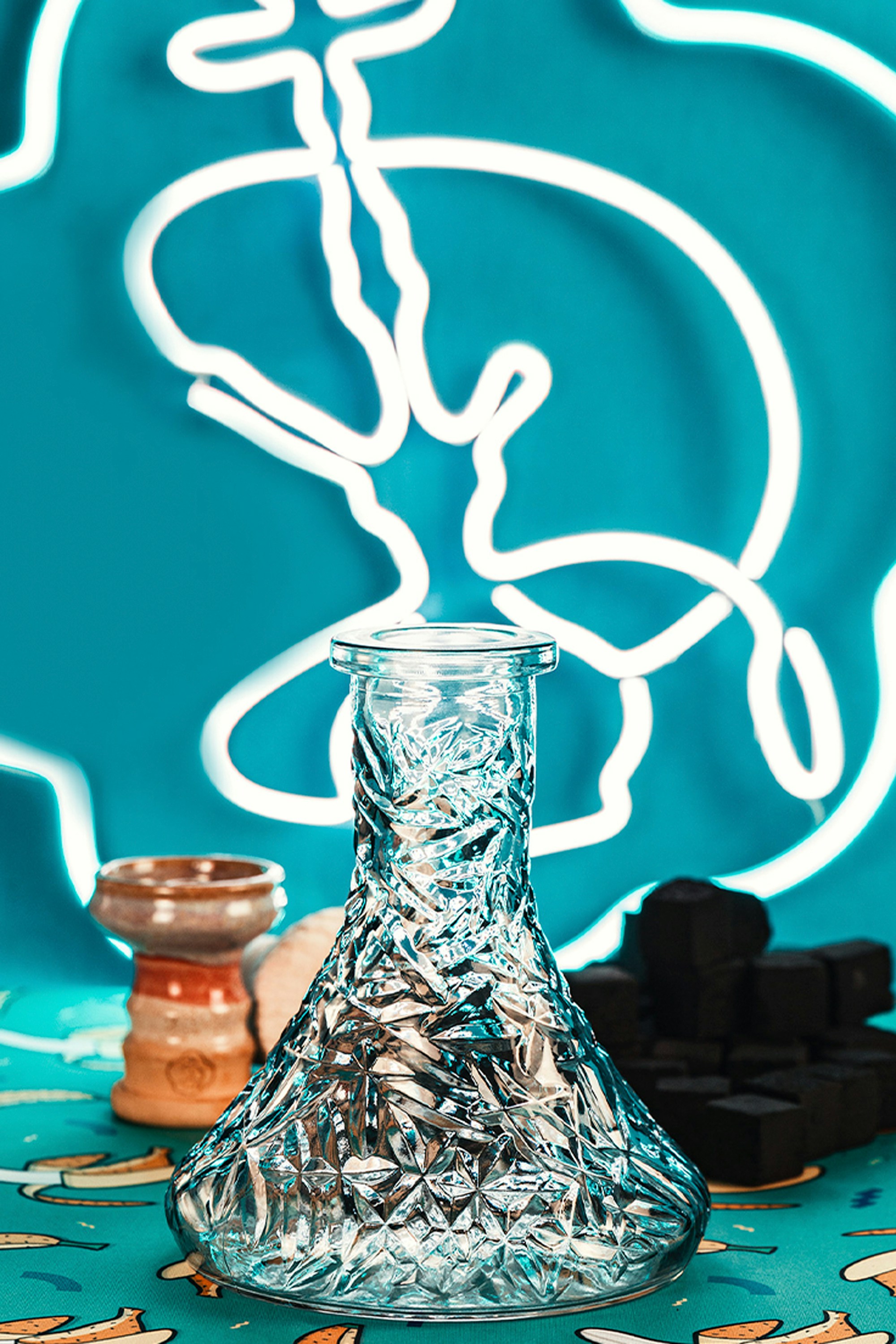 A shisha base with accessories on colorful background.