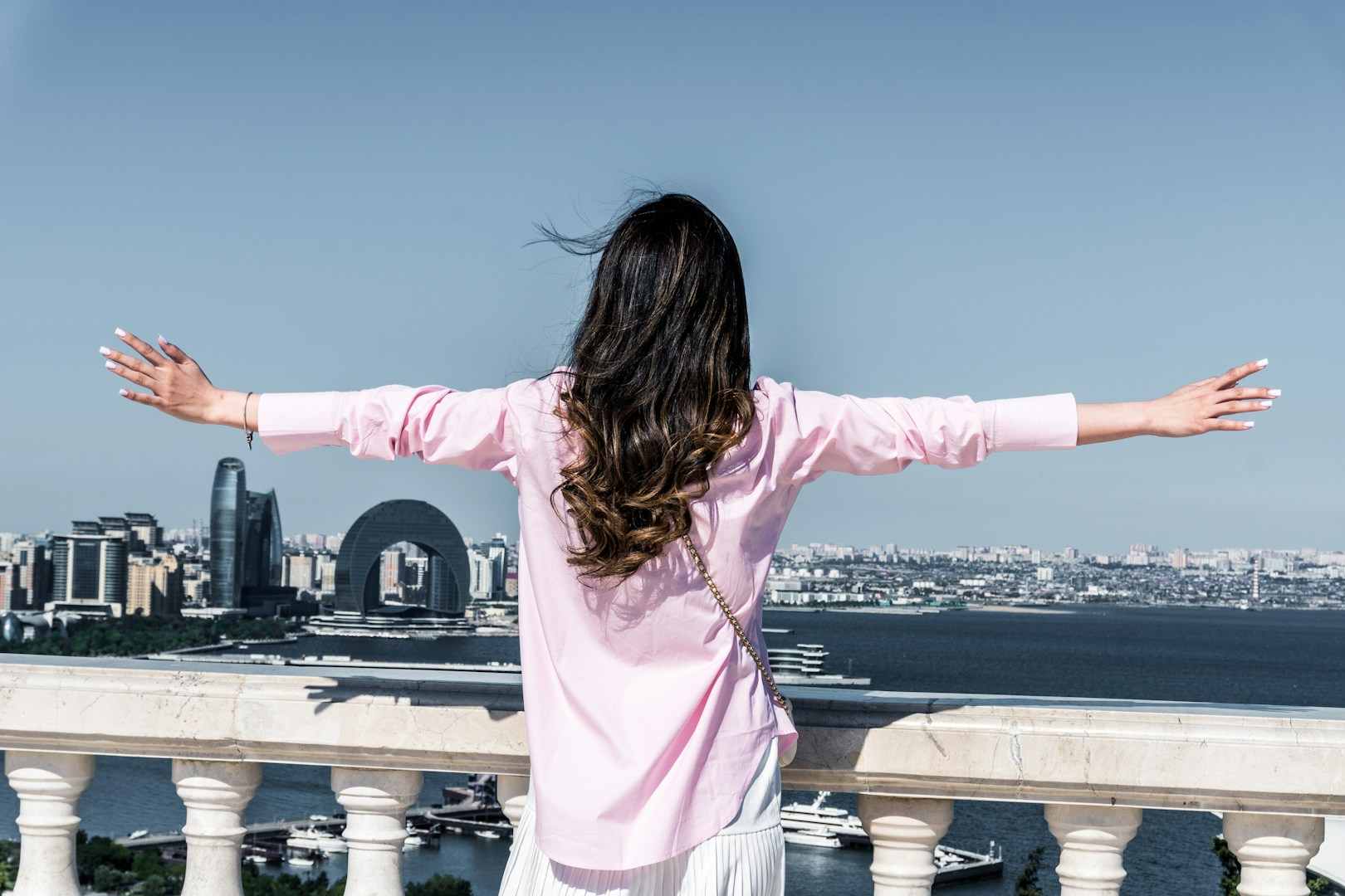 Woman enjoying the city view with arms outstretched — representing financial freedom
