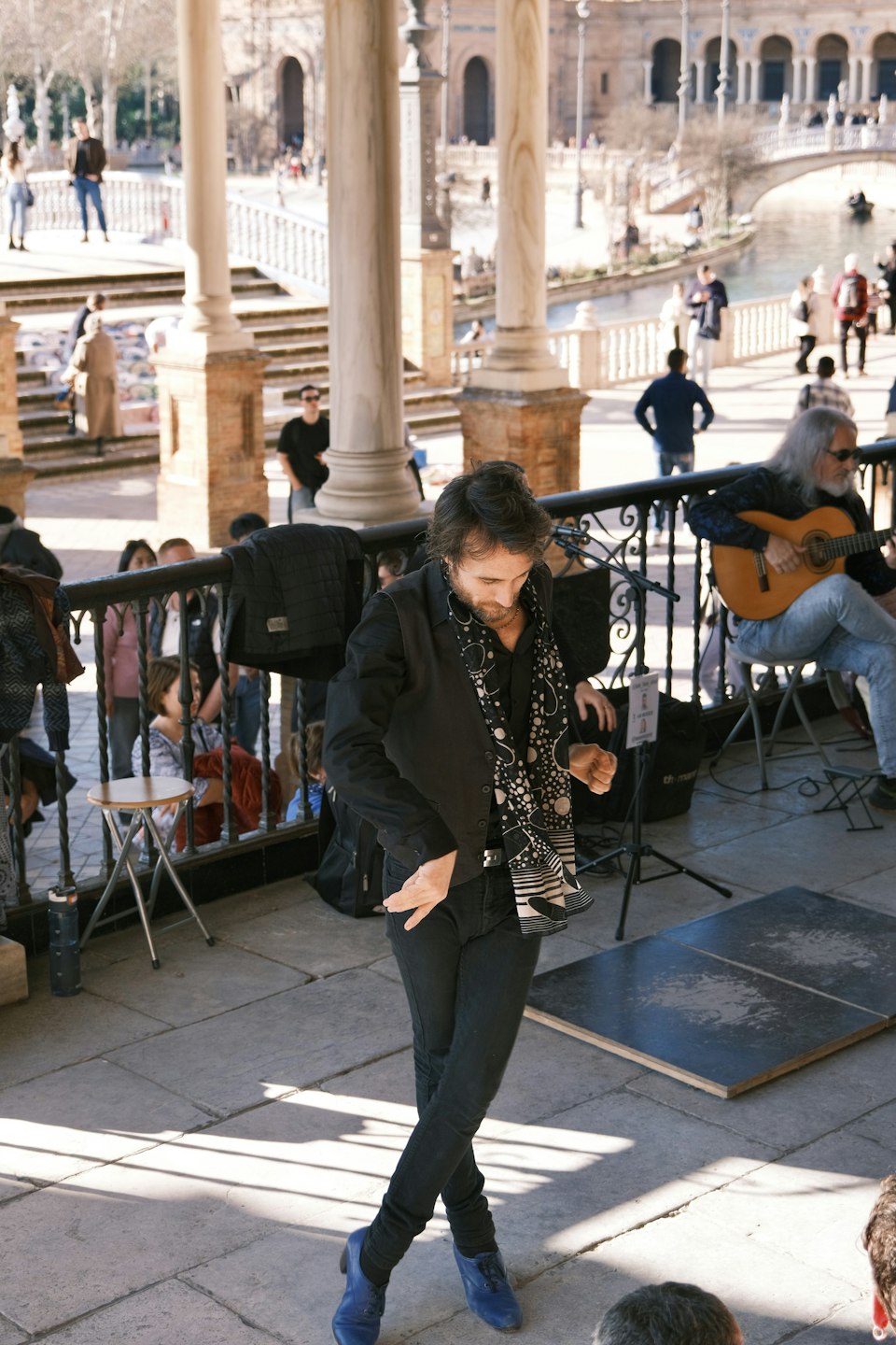 A flamenco dancer performing with a guitarist in the background in Seville