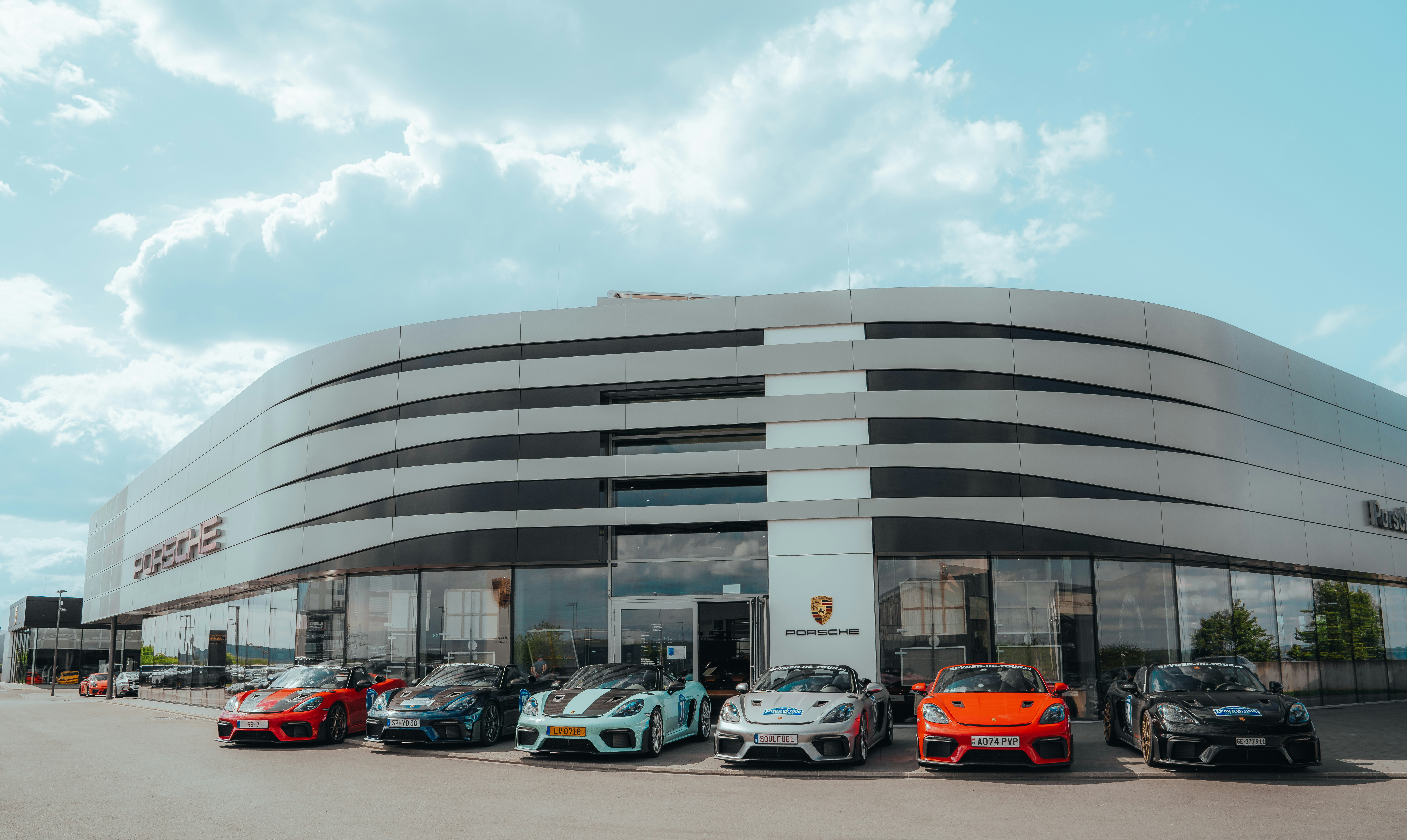 Porsche cars parked in front of the dealership.