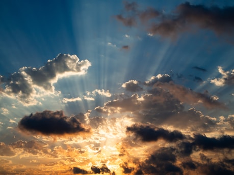 Sunlight bursts through clouds in a beautiful sky.