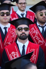 Graduates in caps and gowns at a ceremony.