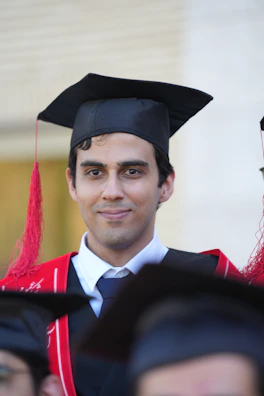 A graduating man smiling proudly in his robes.