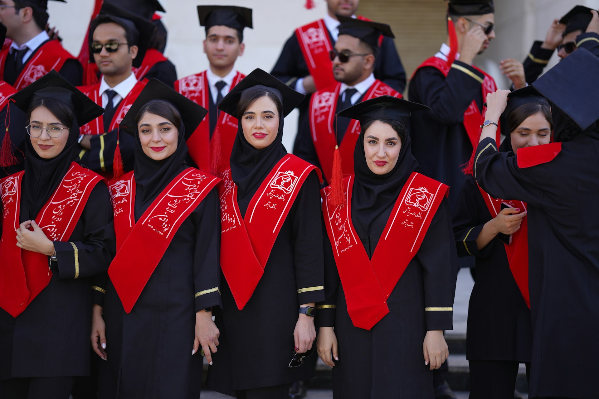 Graduates in robes pose for a celebratory photo.