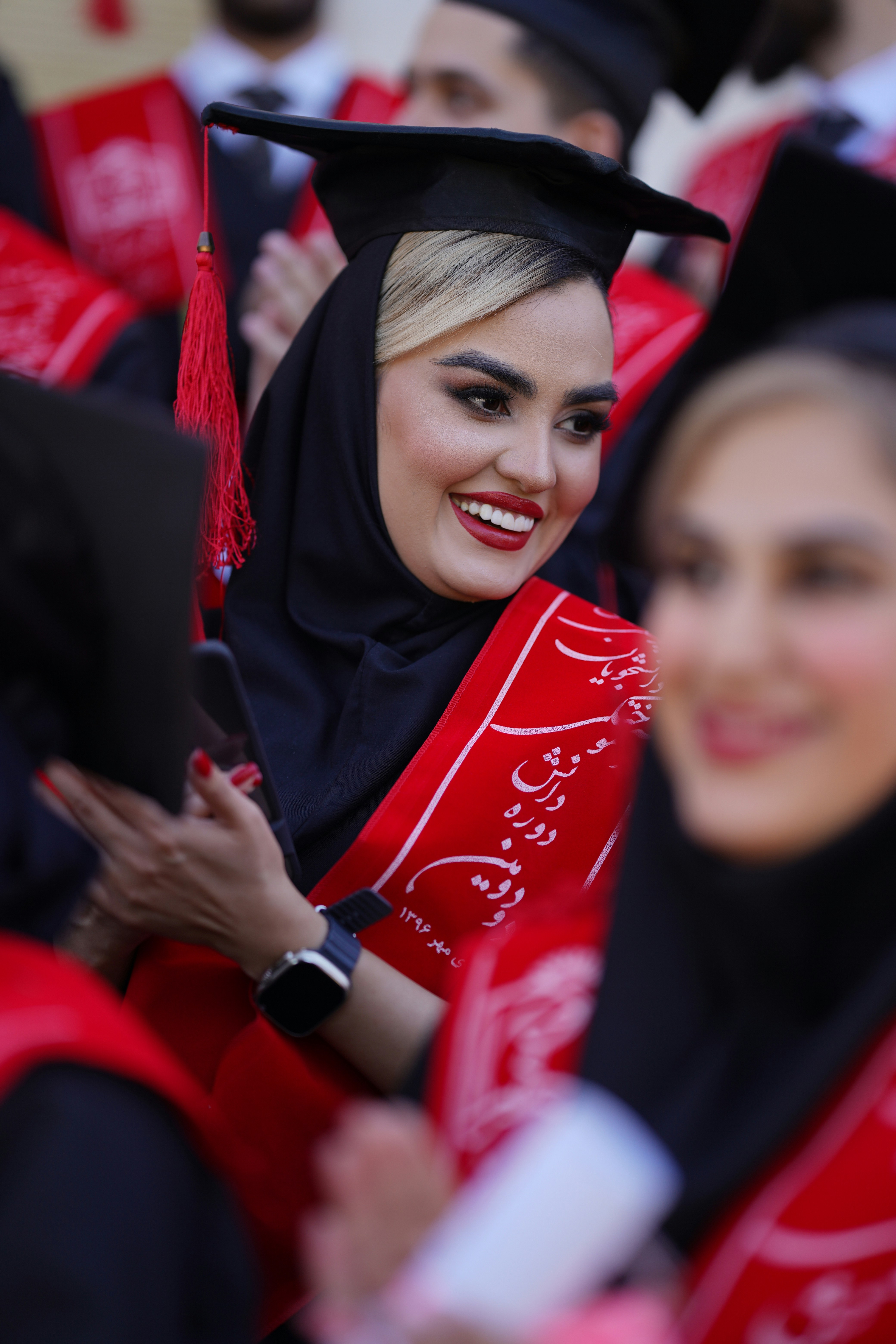 Lulusan merayakan pencapaian mereka dengan senyum dan kegembiraan.