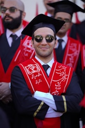 Smiling graduate wearing a graduation cap and gown.