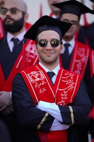 Smiling graduate wearing a graduation cap and gown.