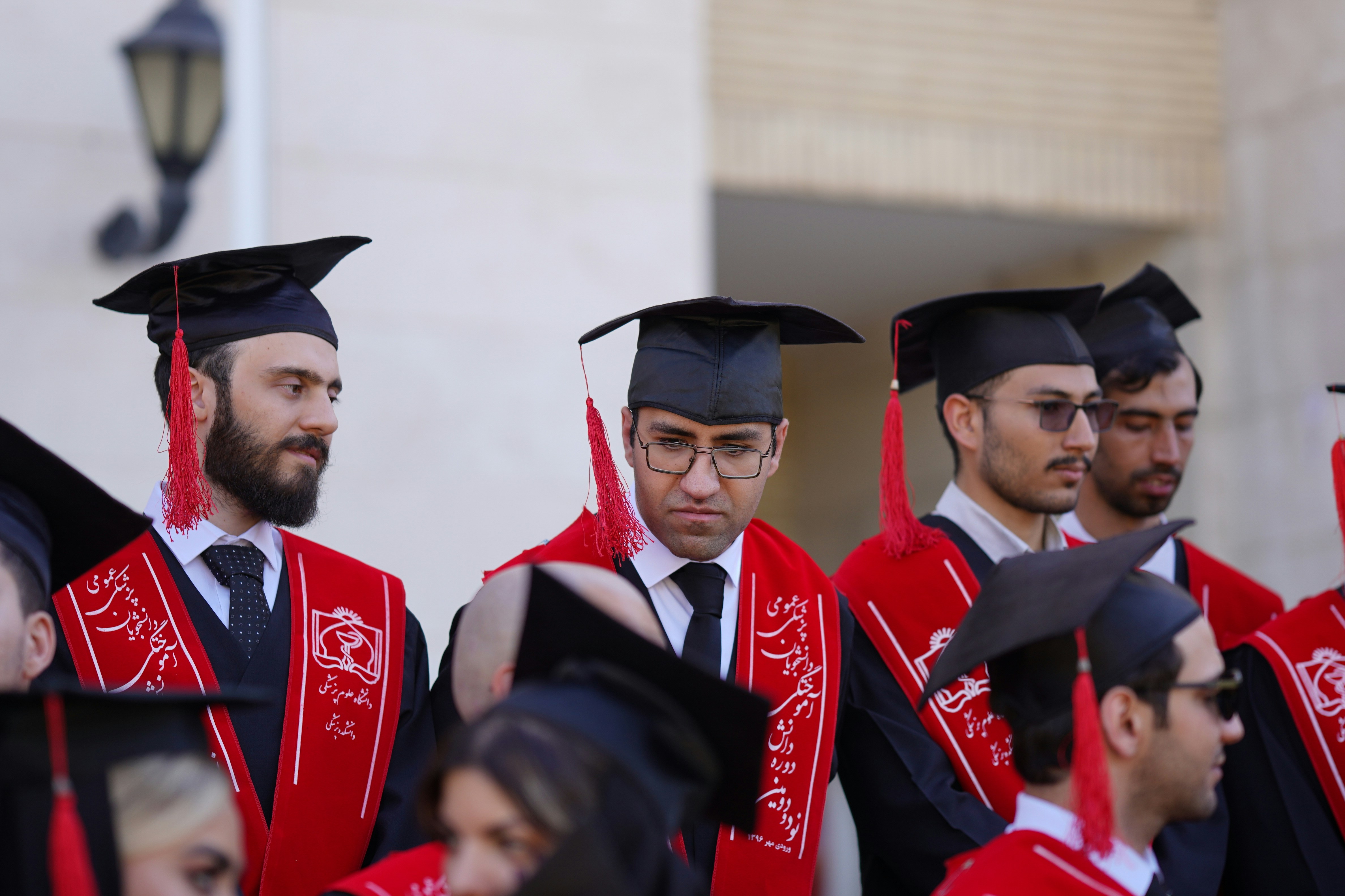 Graduates wear caps and gowns, ready for commencement.