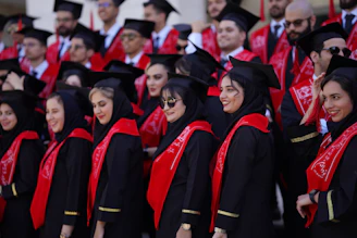 Graduates pose together, dressed in their robes.