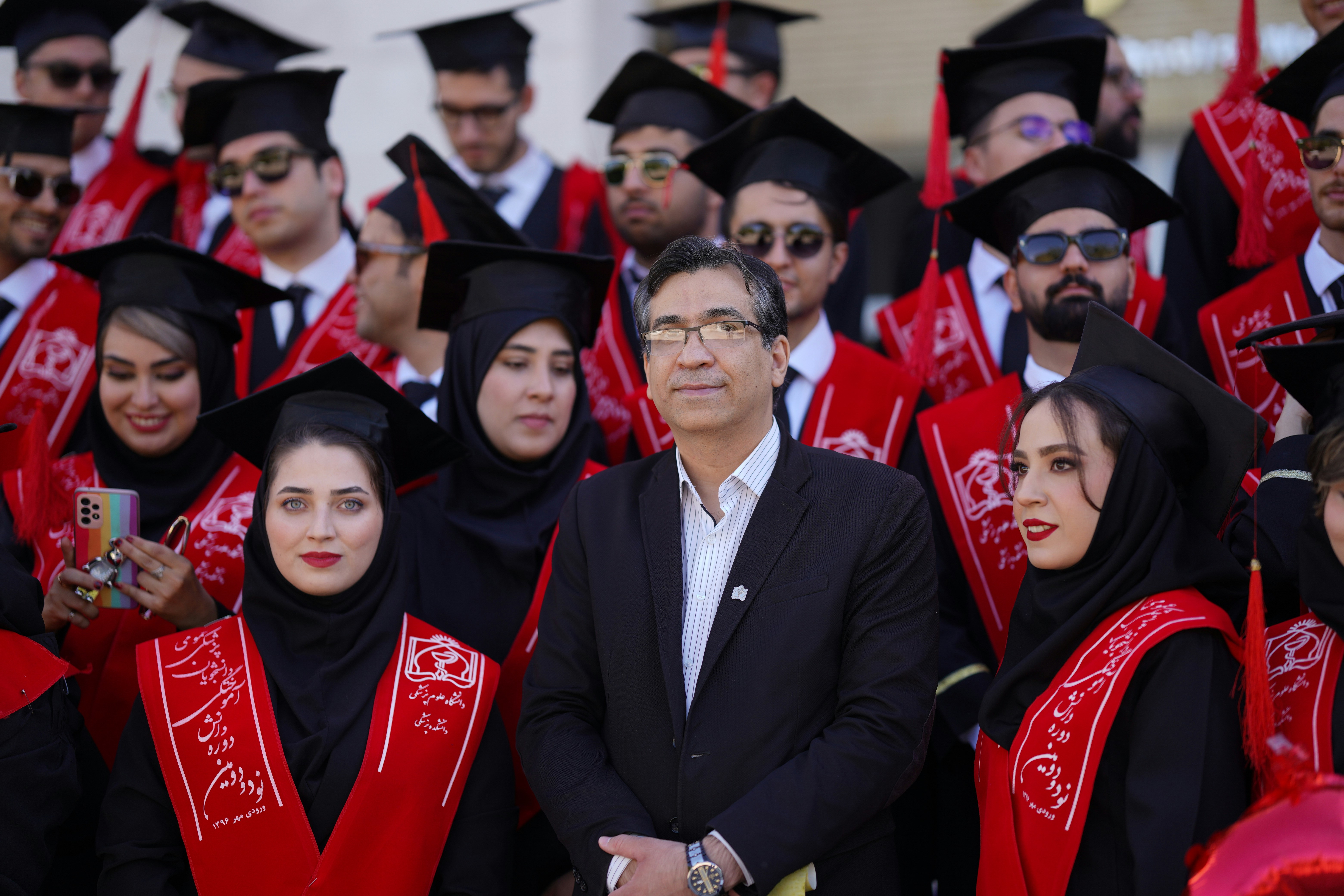 Graduates pose for a photo at a graduation ceremony.