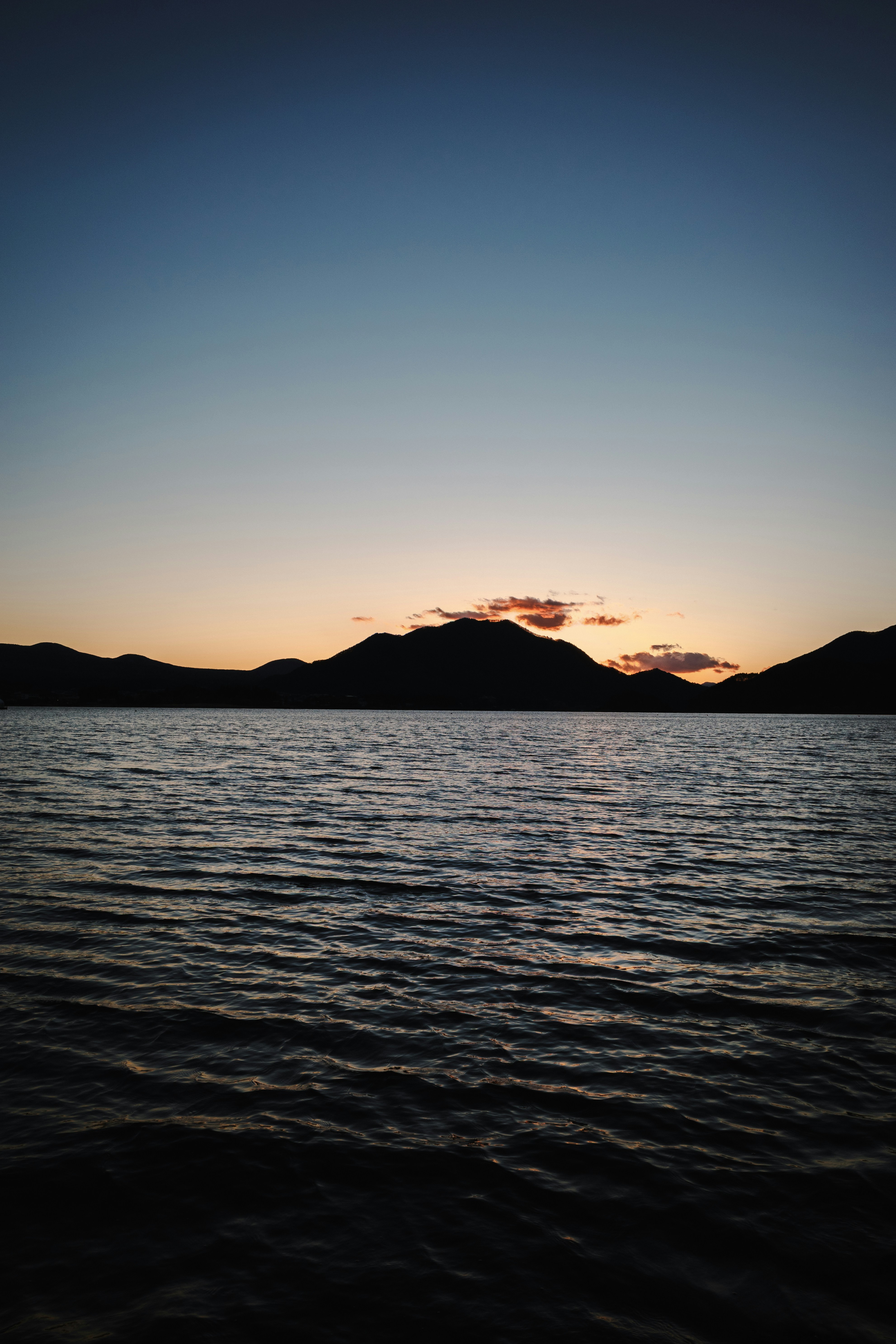 Sunset over a lake and mountains.