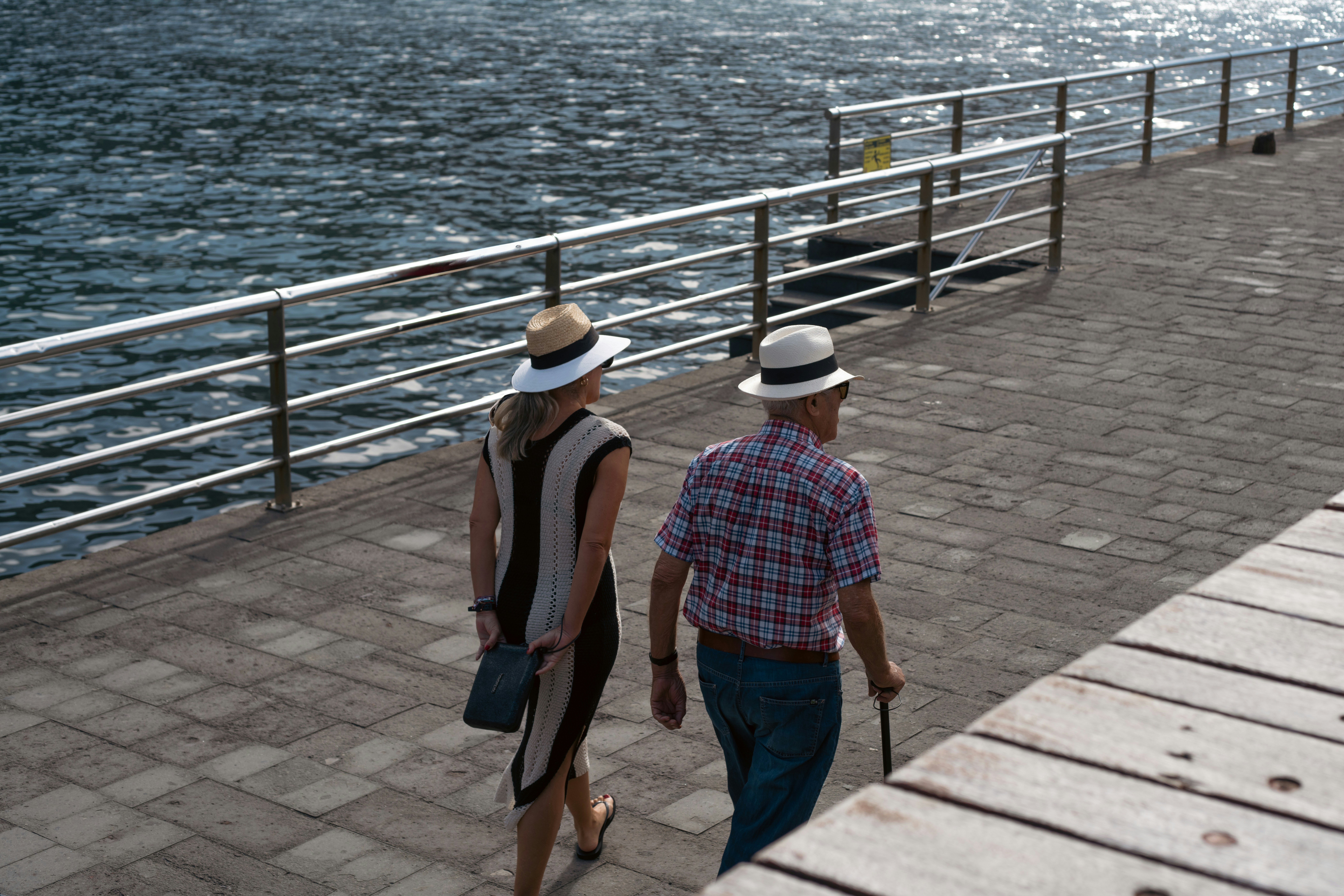 Un couple se promène le long d’une jetée à côté de l’océan.
