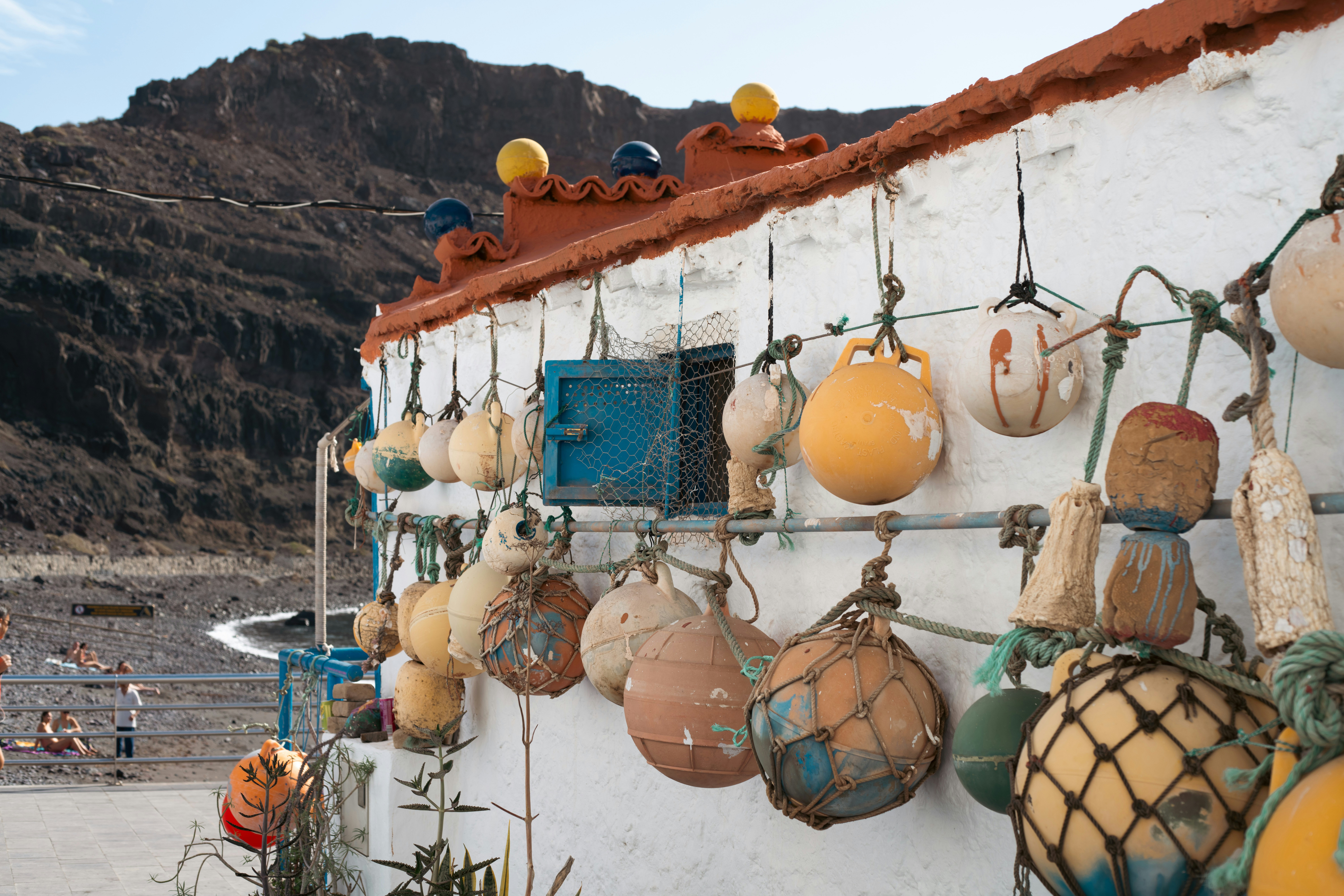 Buoys hang on a building near the sea.