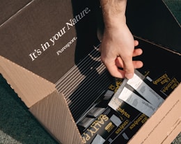 A person opens a box of electrolyte packets.