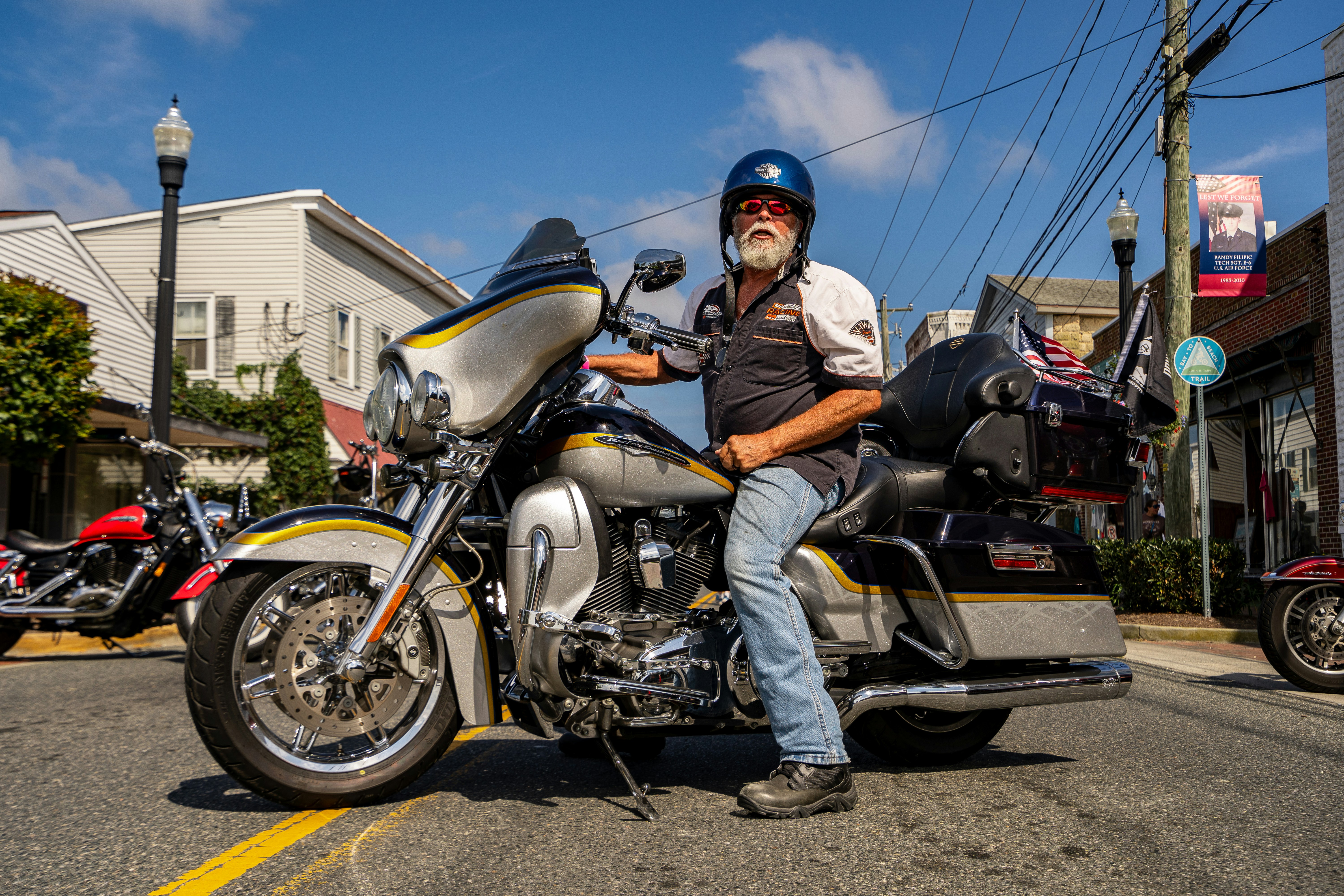 A biker sits on his motorcycle on a street.