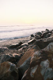 Rocky shoreline meets the ocean under a pale sky.