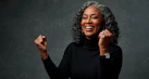 Smiling woman with gray hair celebrates her success.
