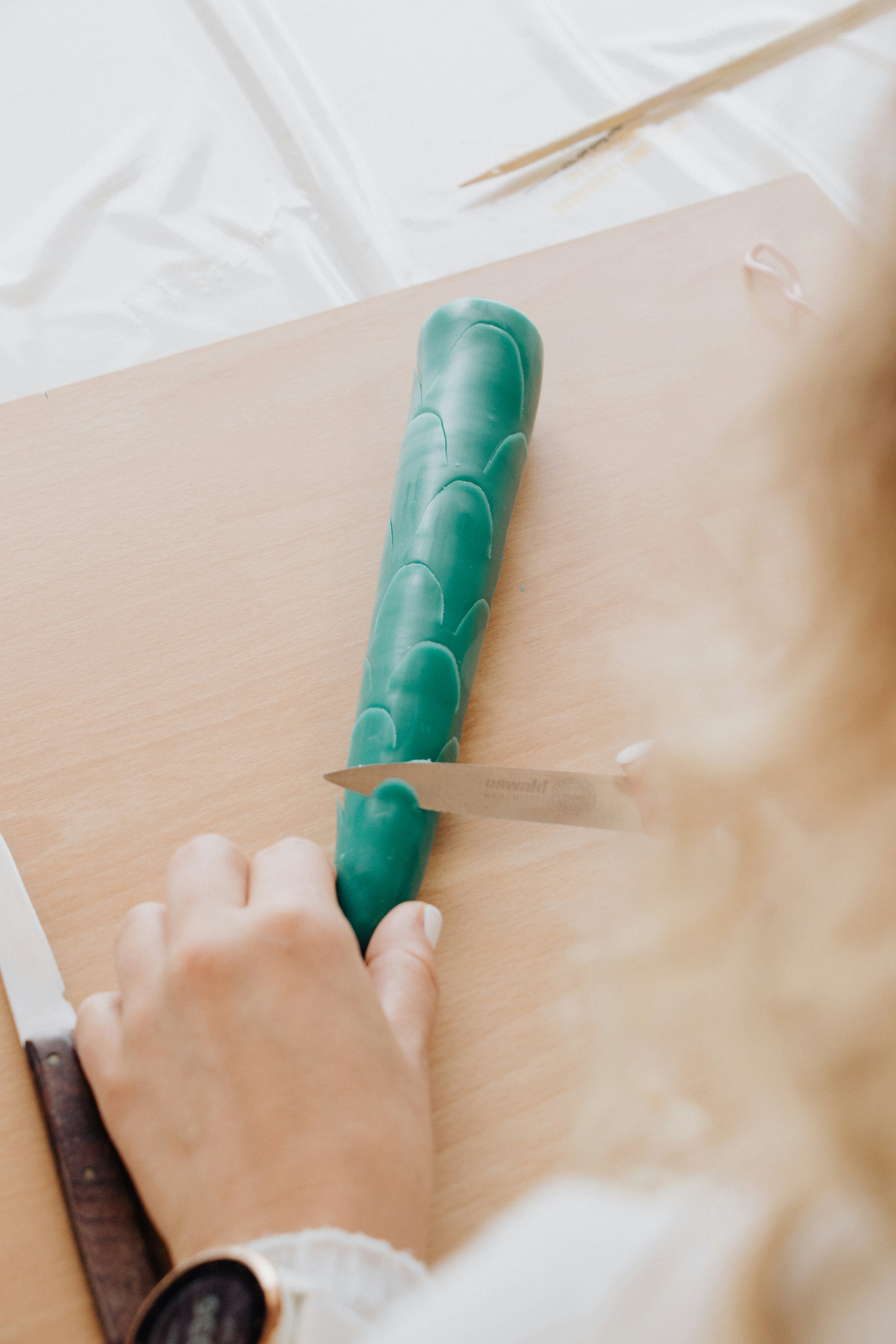Someone is cutting a green, textured object.