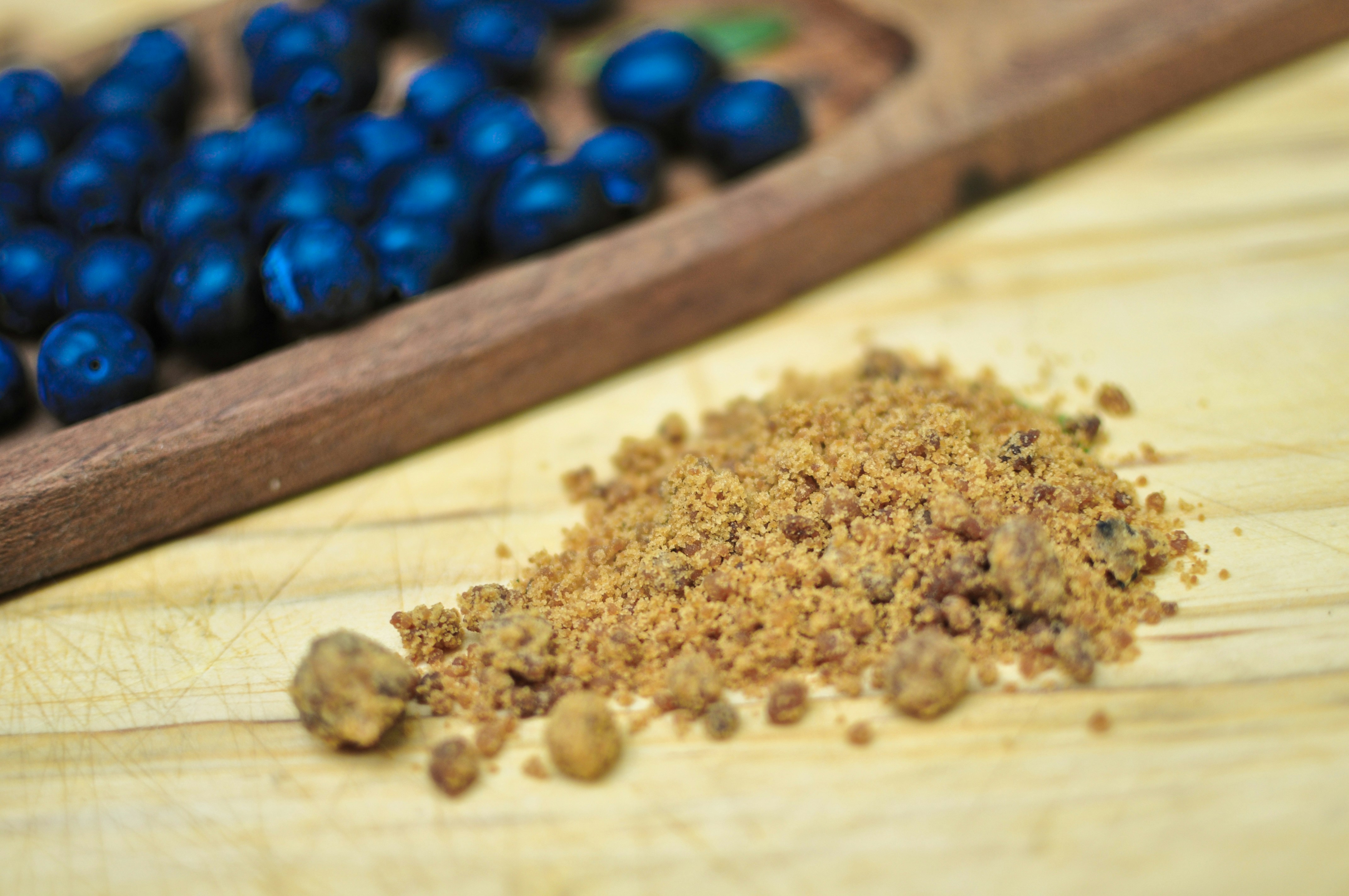 Blueberries and brown sugar on a wooden surface.