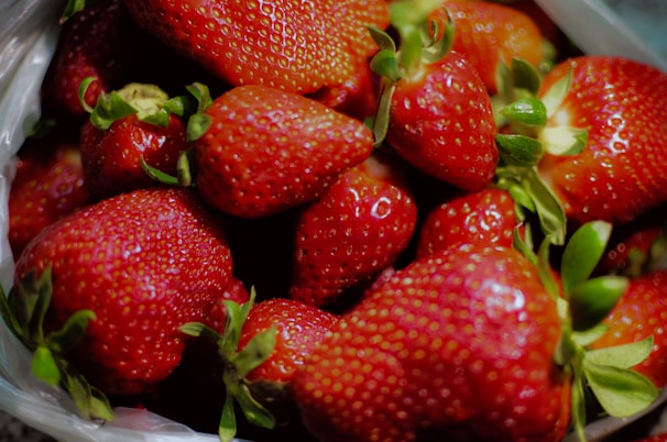 Fresh, ripe strawberries are piled up in a bag.