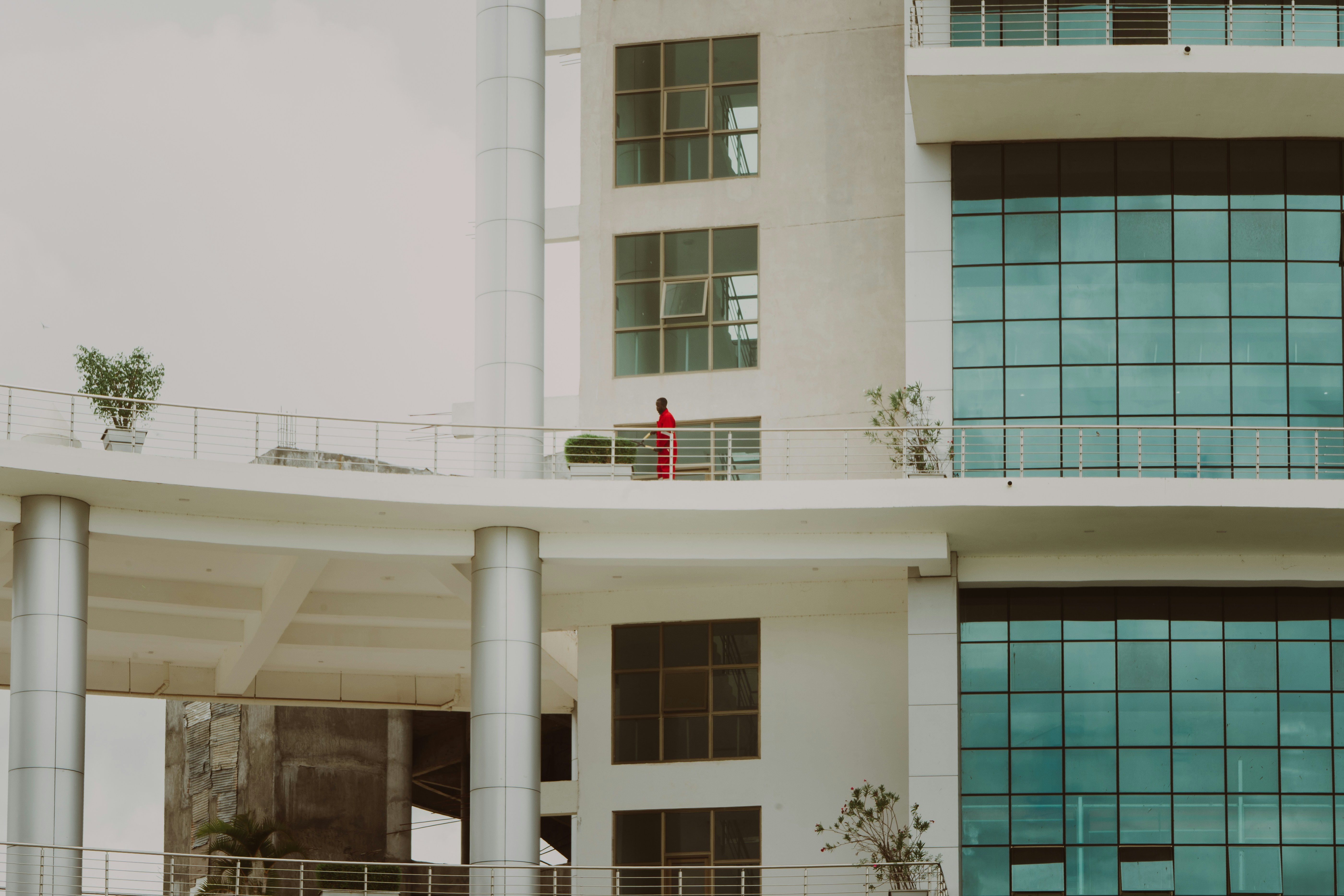 A person walks on a balcony of a building.