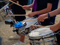 Drummers are playing drums with drumsticks.