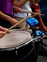 People are playing drums with drumsticks.