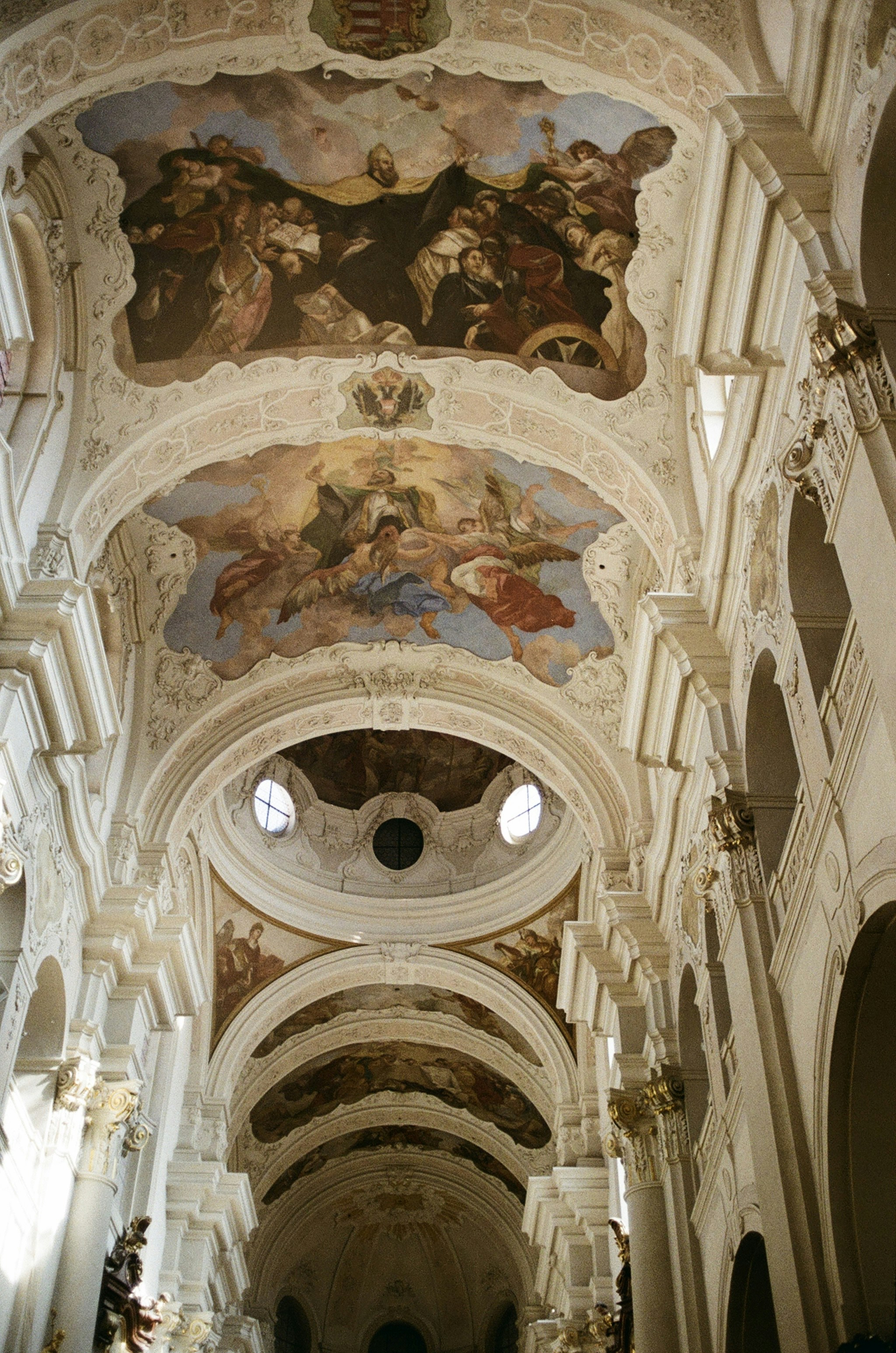 Inside of a church with colorful ceiling paintings.