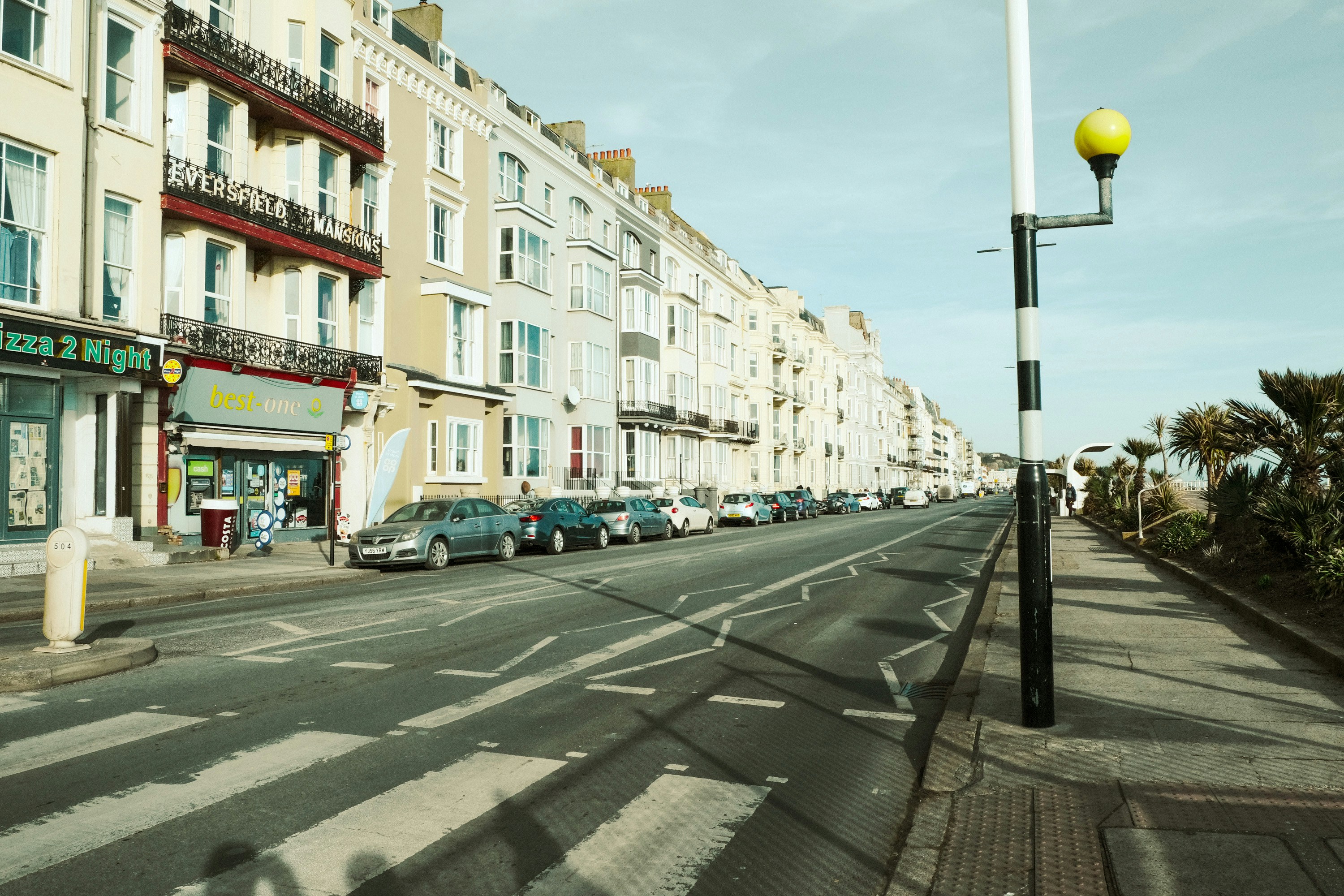 A street lined with buildings and parked cars.