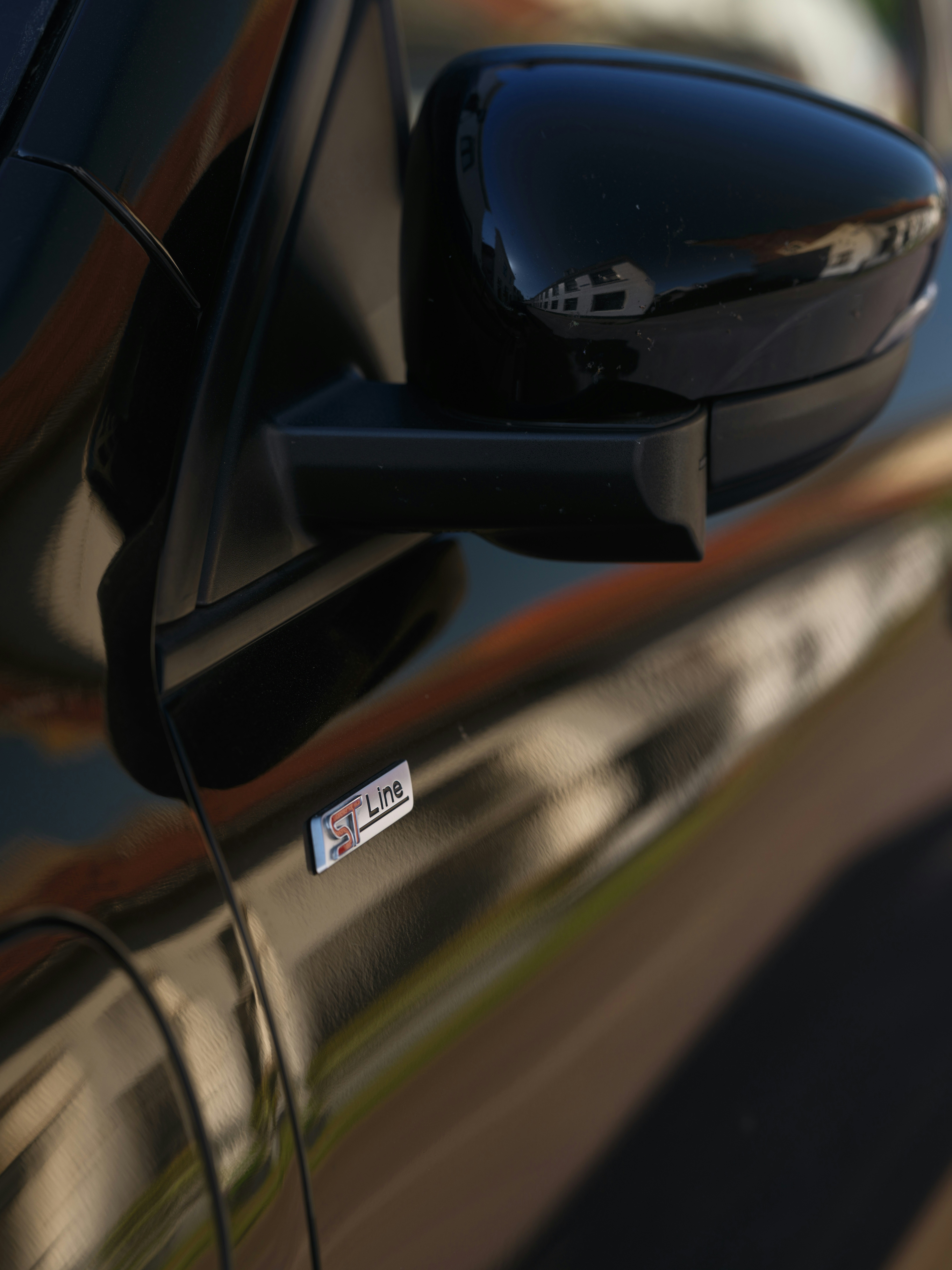 Vue rapprochée du rétroviseur latéral d’une voiture.