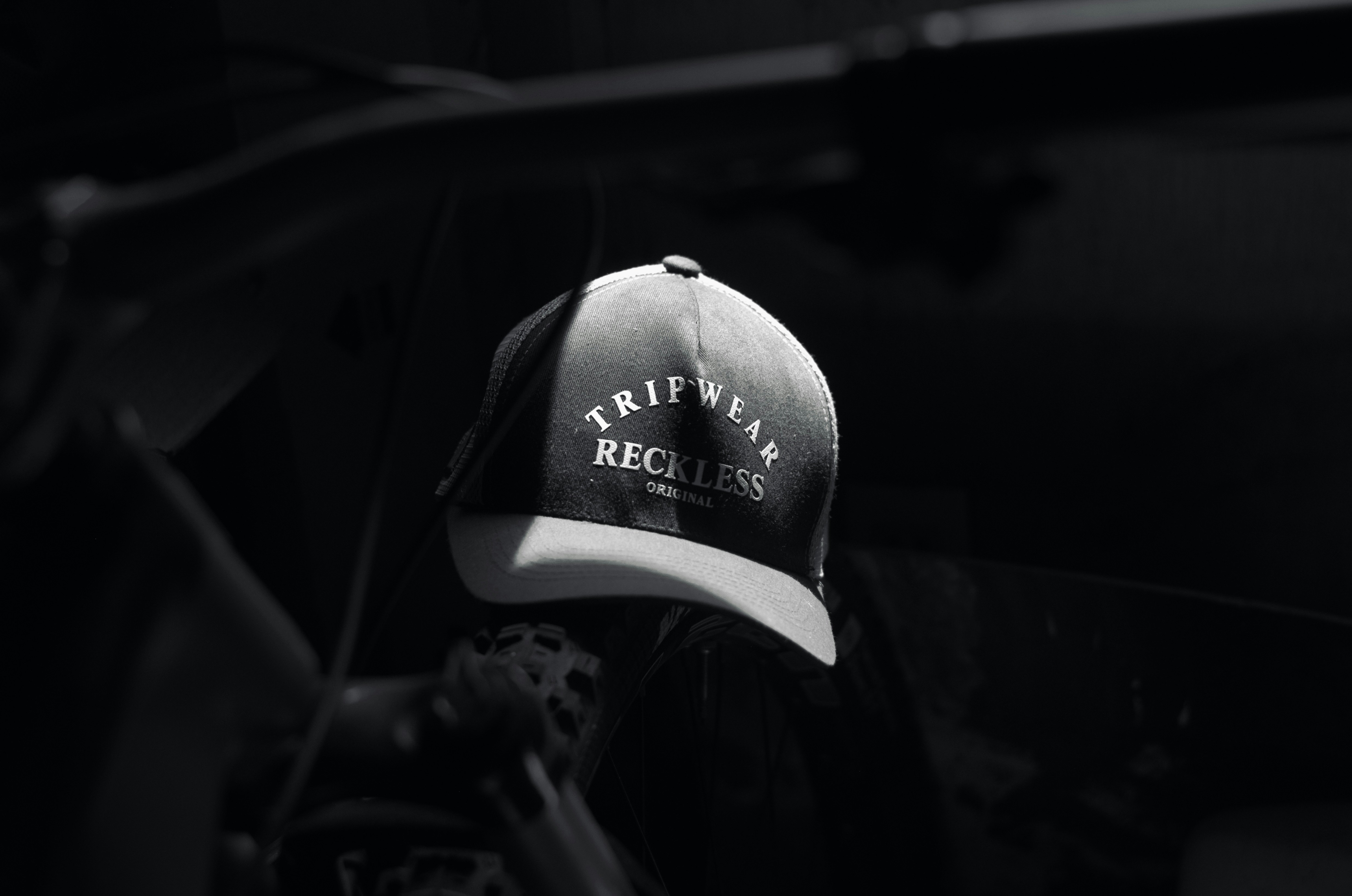 A baseball cap hangs in a dark, blurred environment.