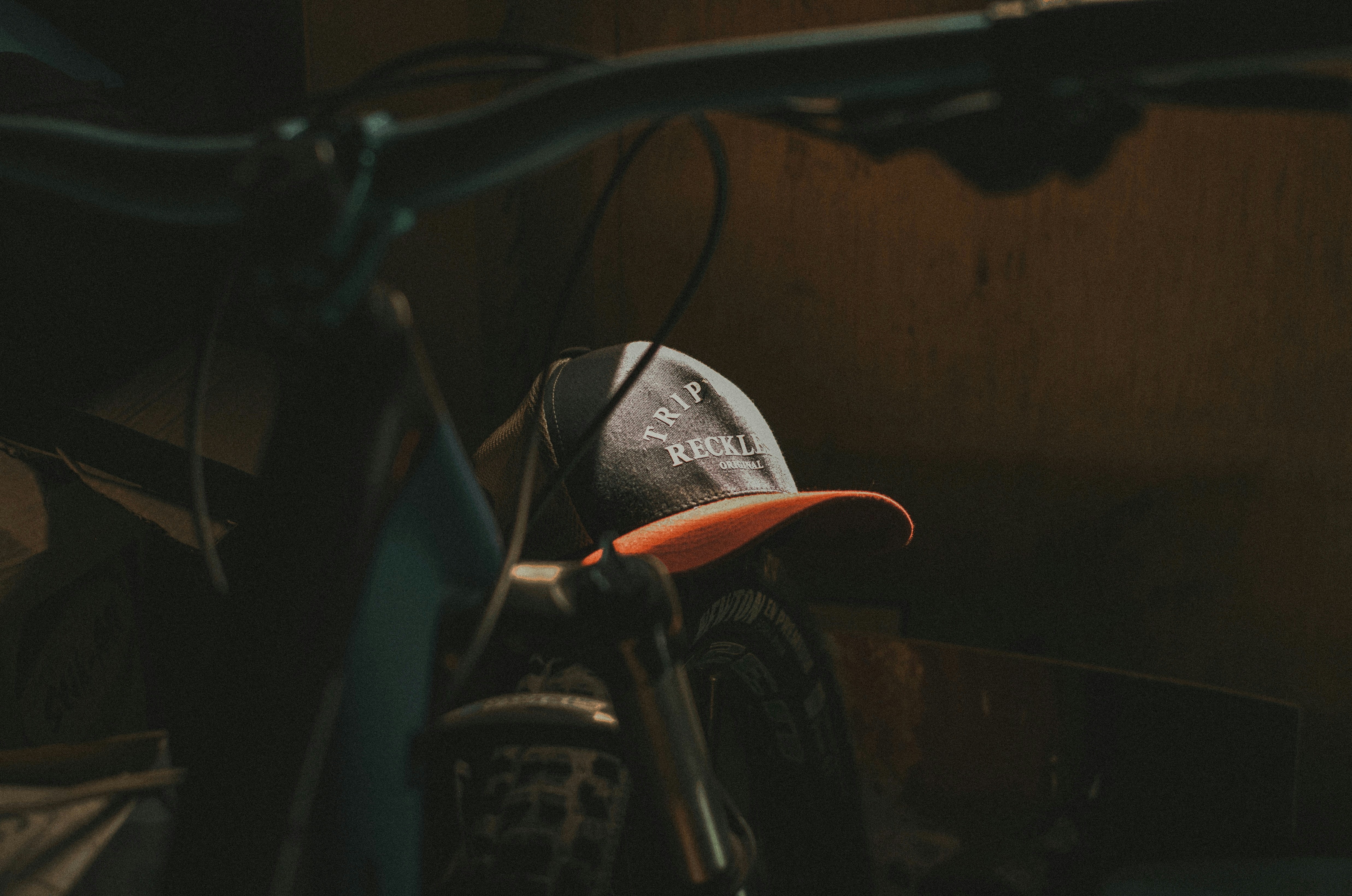 A bicycle with a cap sits in the dark.