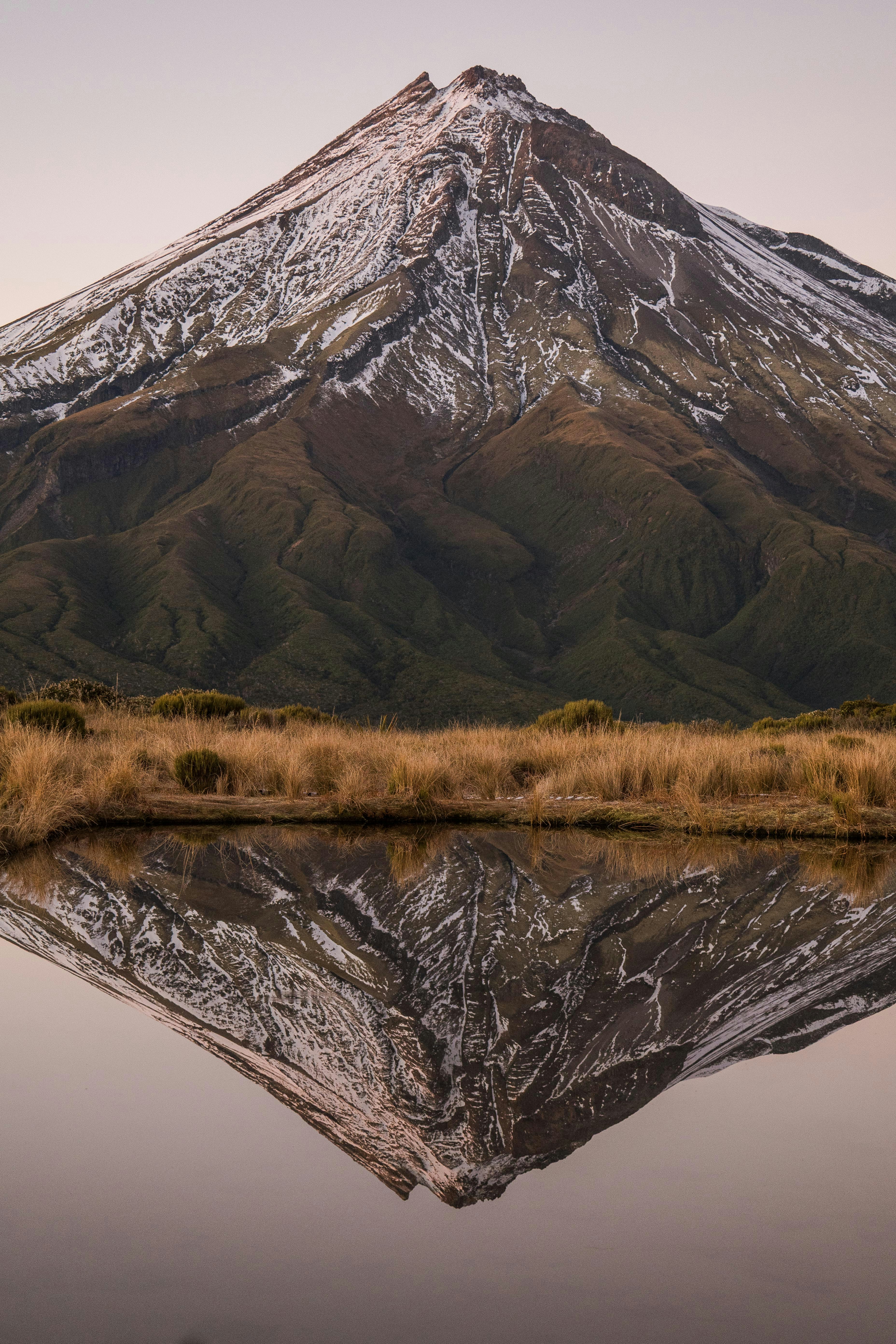 Snowy mountain reflected in still water.