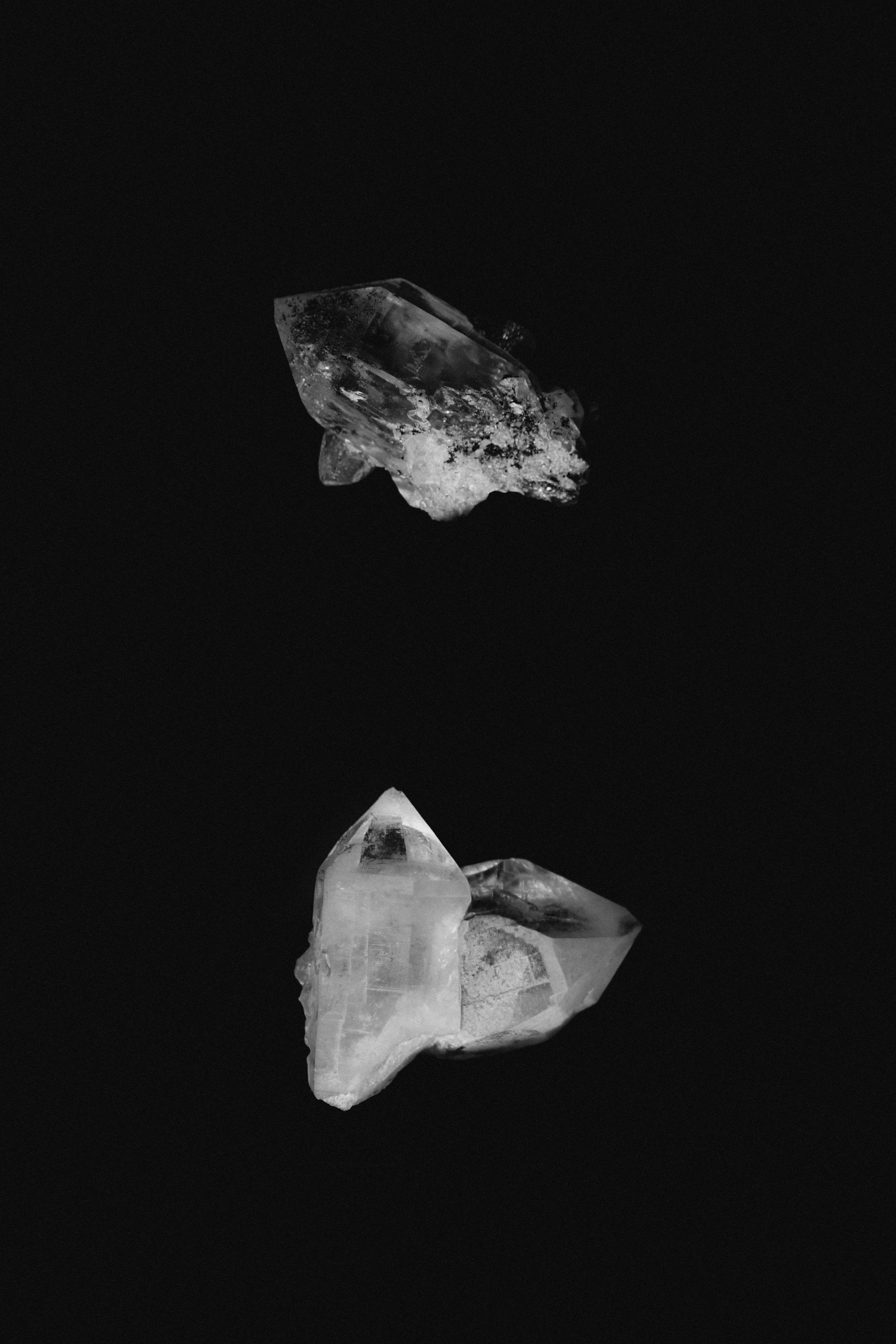 Two transparent crystals on a black background.