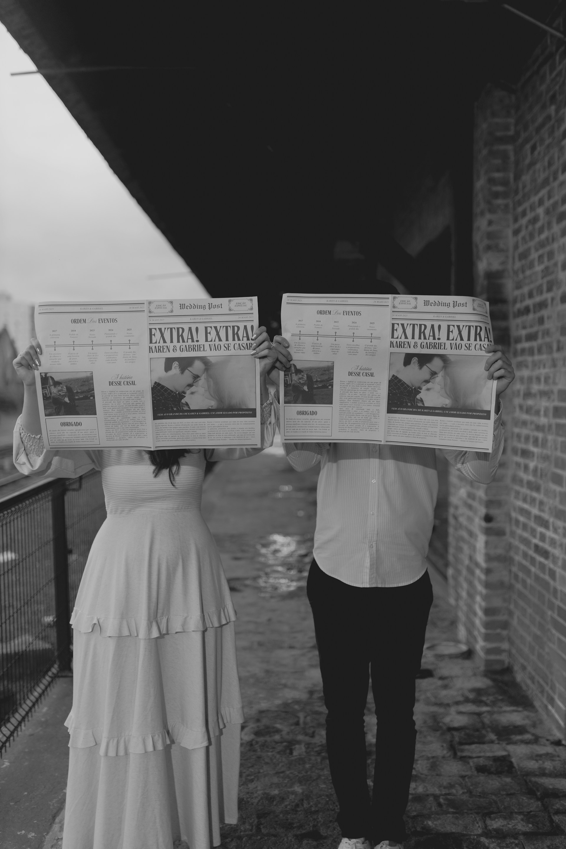 Couple holds newspapers to celebrate their relationship.