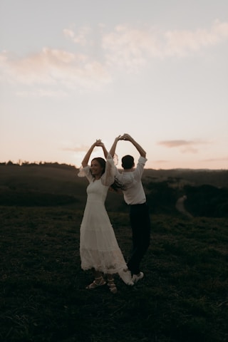 Couple forms a heart with their arms.