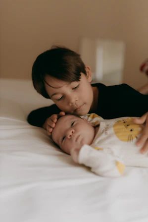 Older brother tenderly cuddles baby brother.