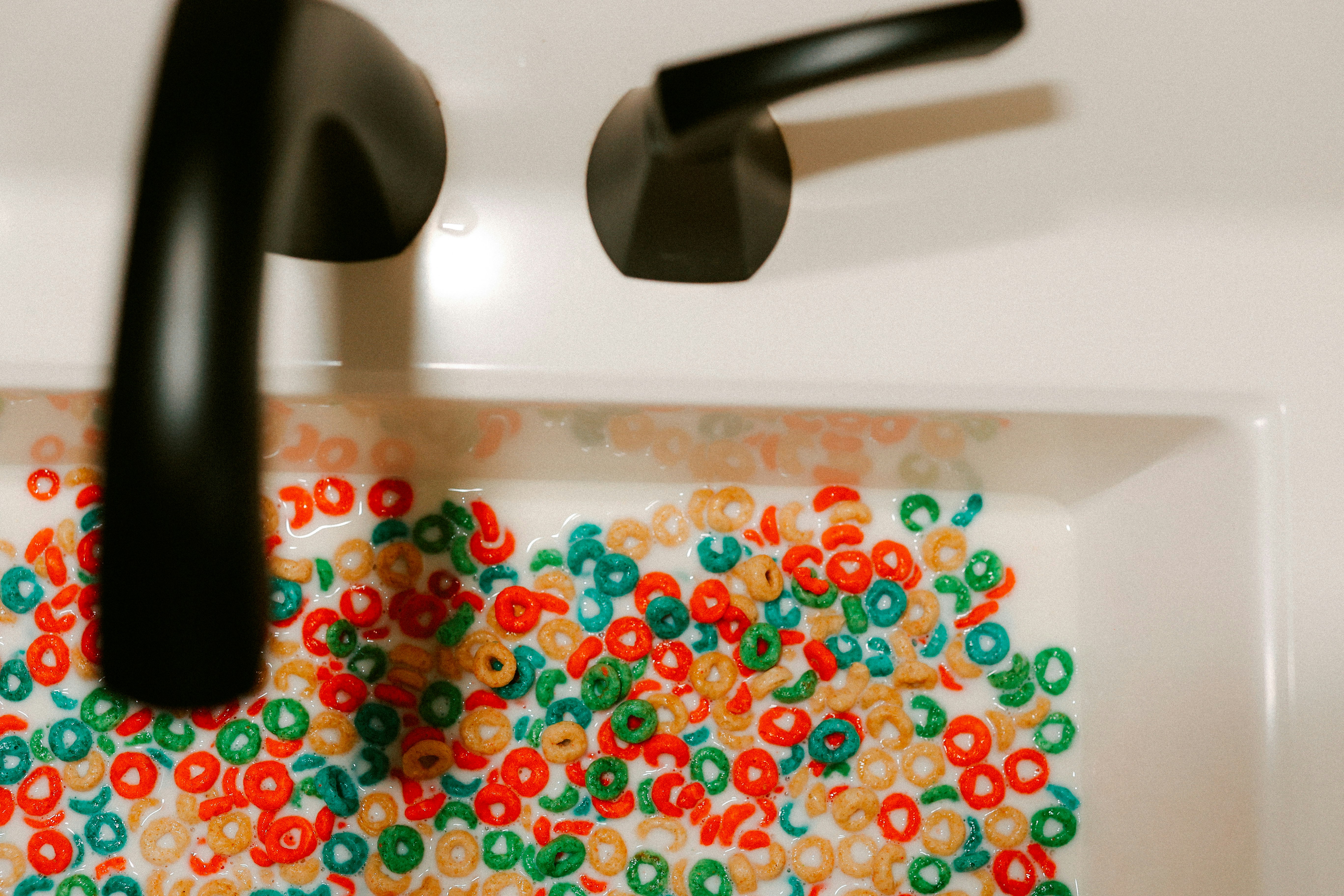Cereal is in a sink with a faucet.