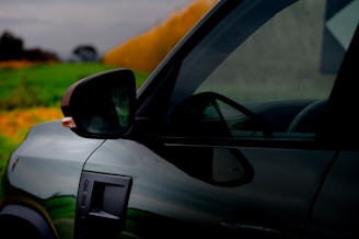 A dark car is seen outdoors.