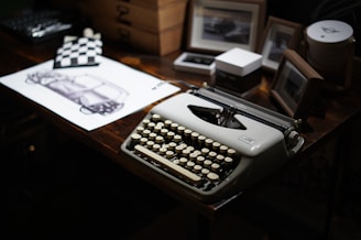 A vintage typewriter sits on a dark desk.