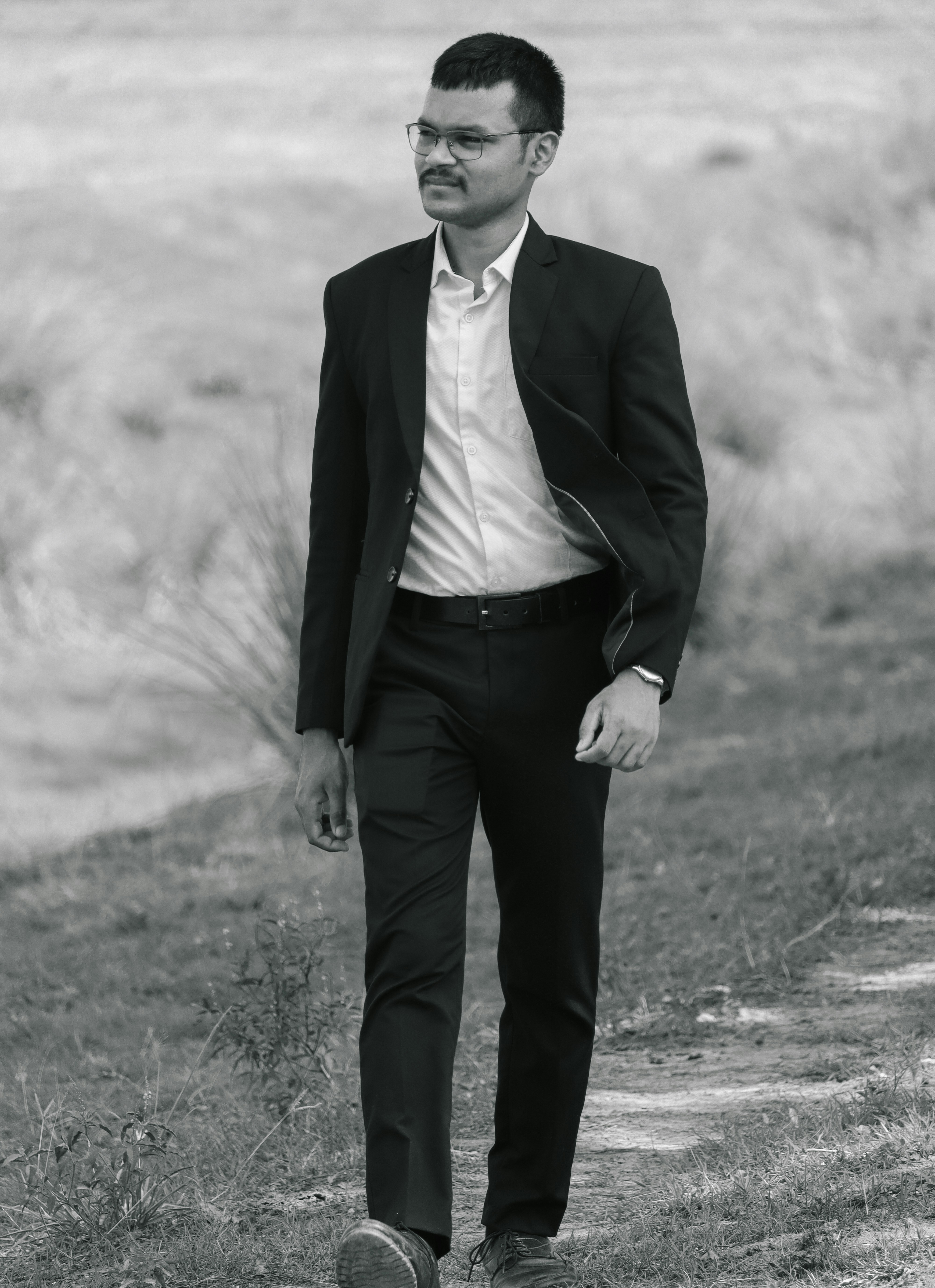 A man in a suit walks outside.