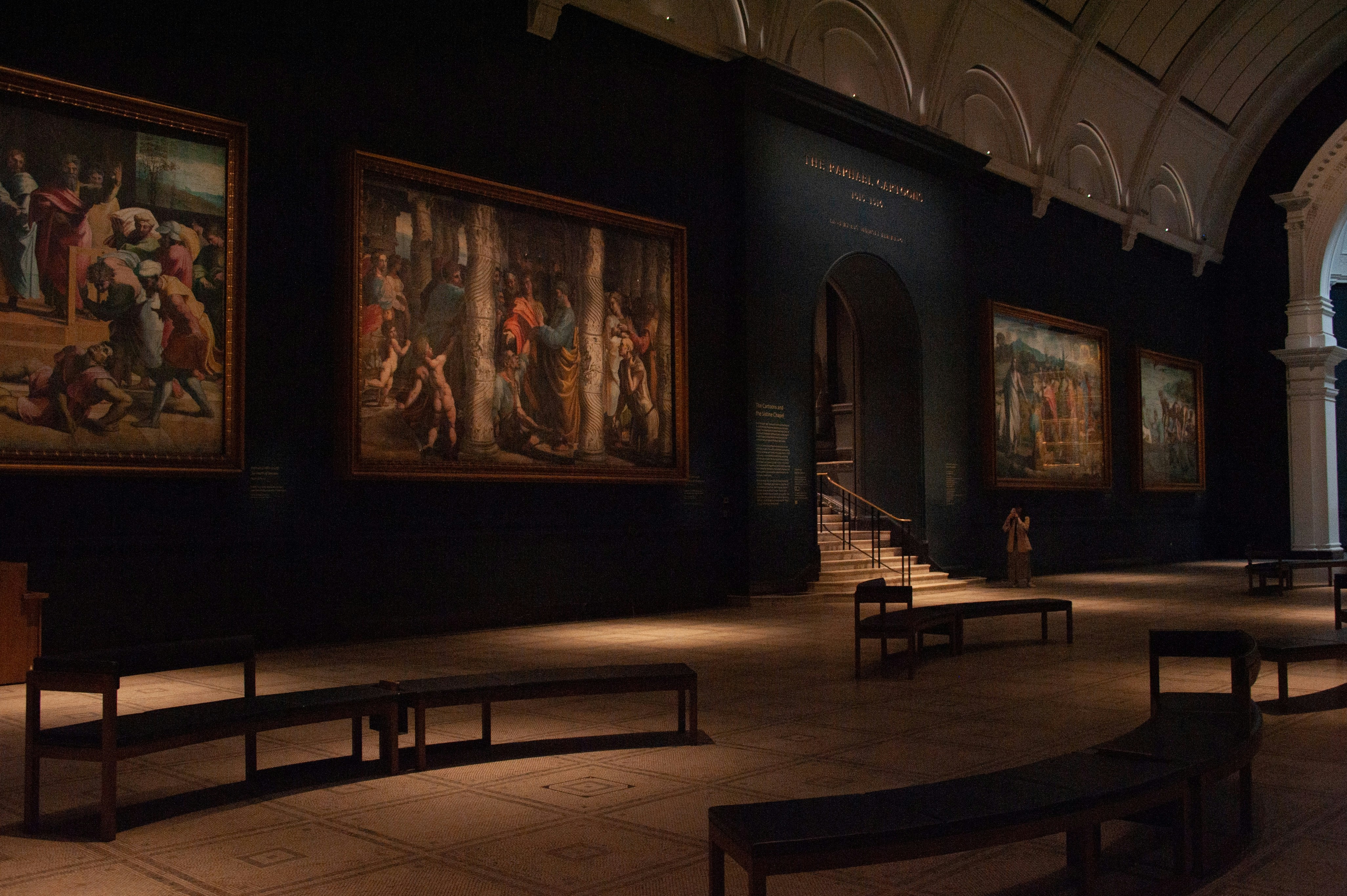 Inside of a grand museum exhibiting paintings.