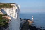White cliffs and a lighthouse overlook the sea.