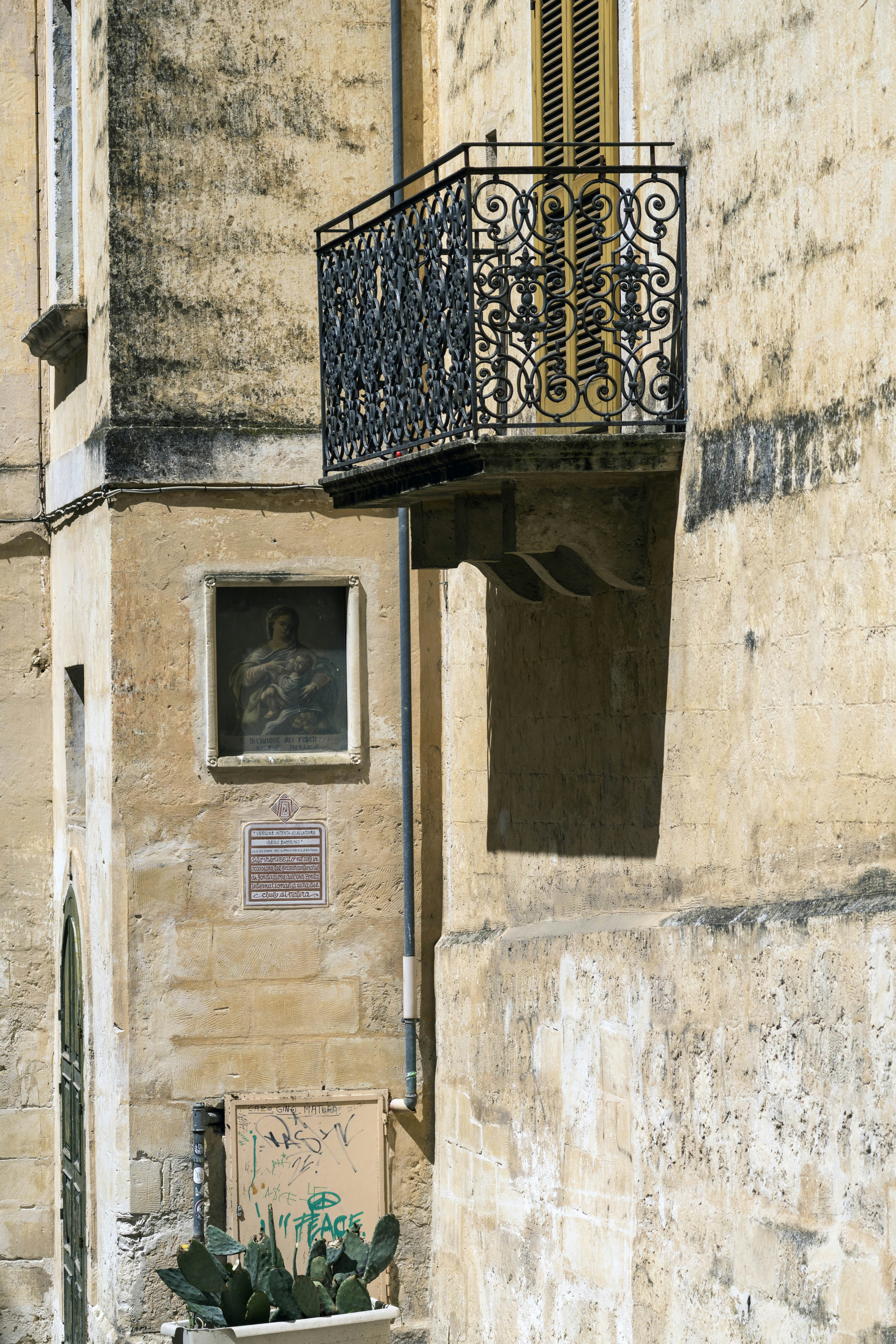 Balcony and wall with a painting and cactus.