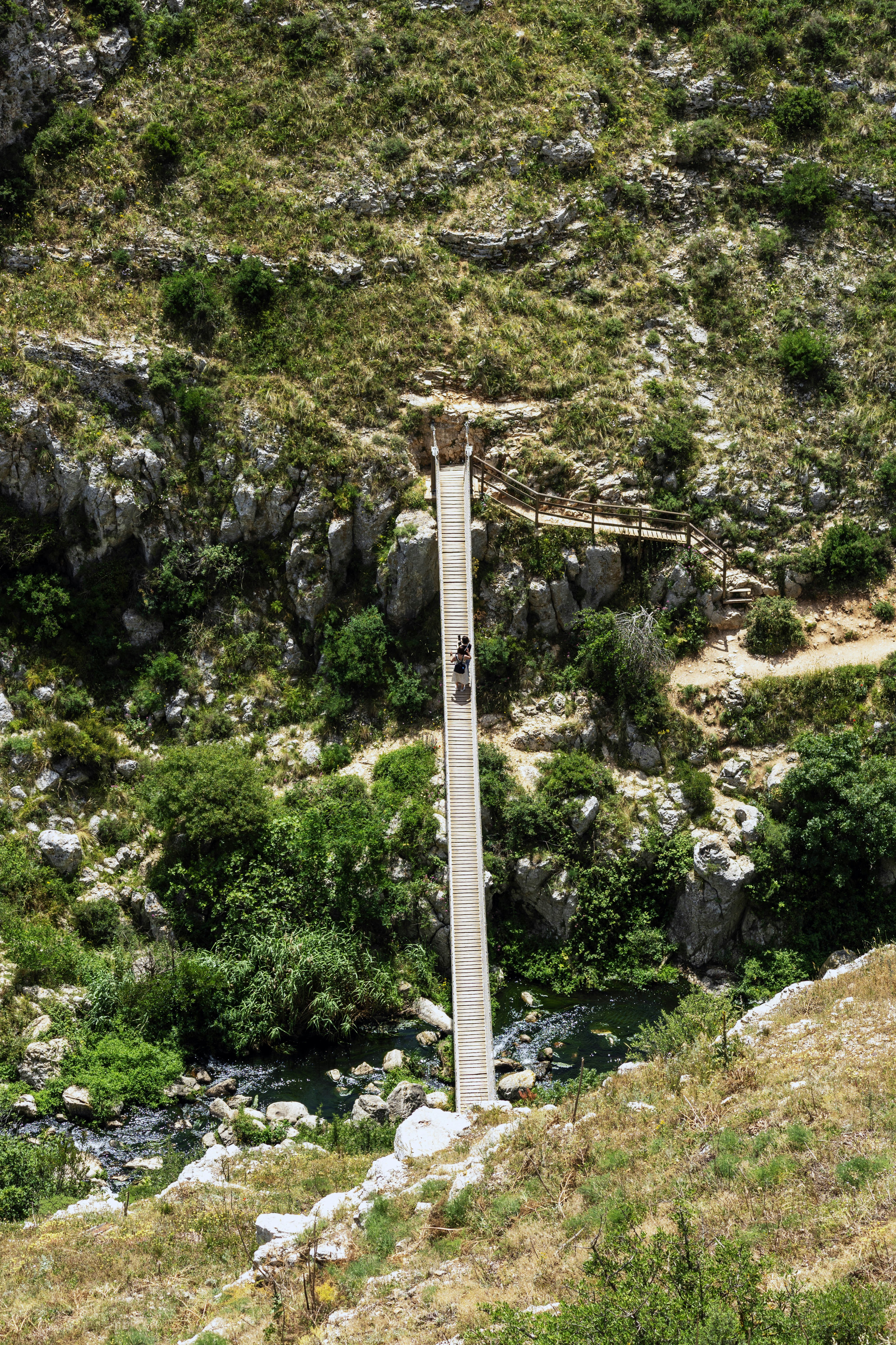 A narrow bridge spans a deep gorge.