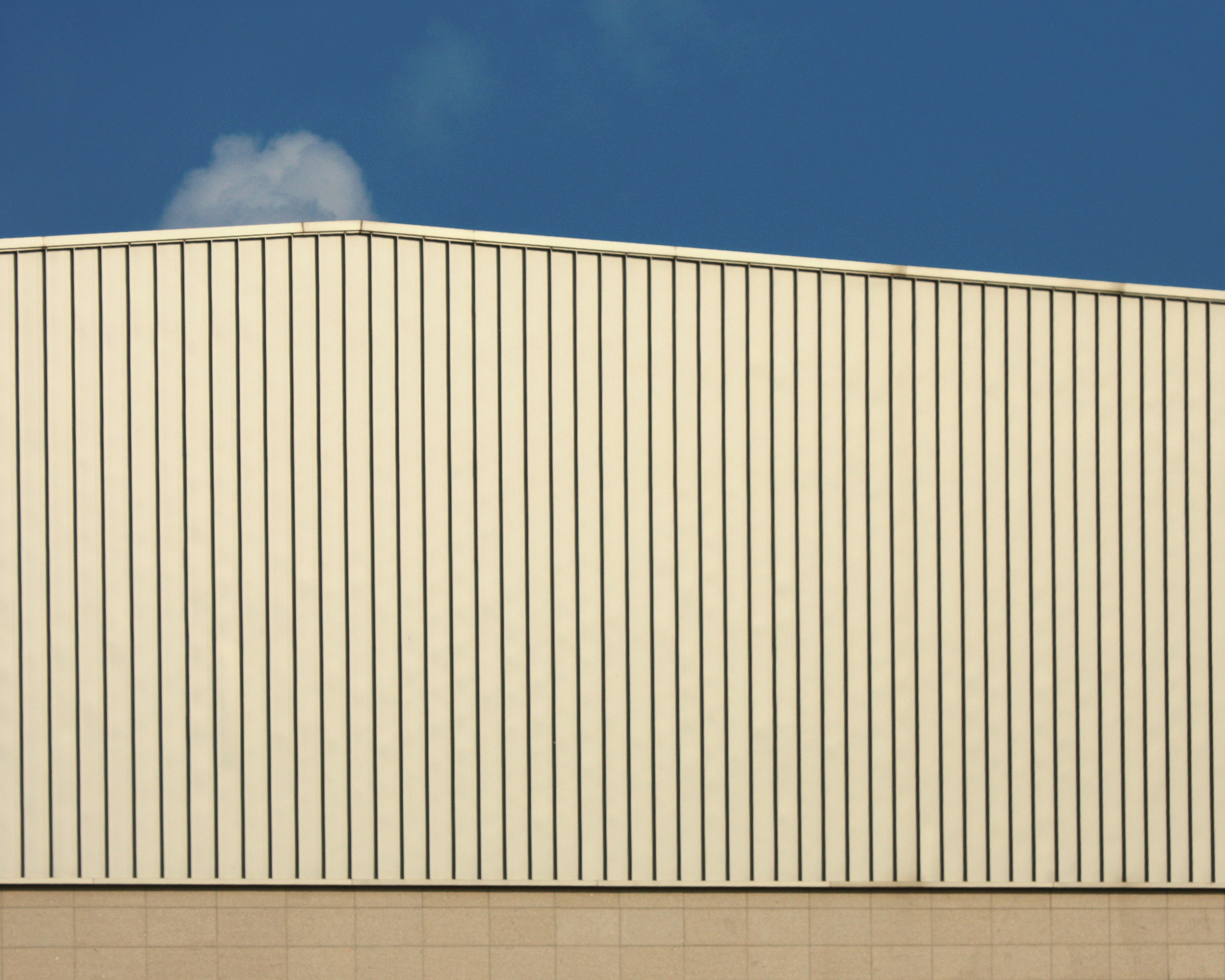 A metal building against a blue sky.