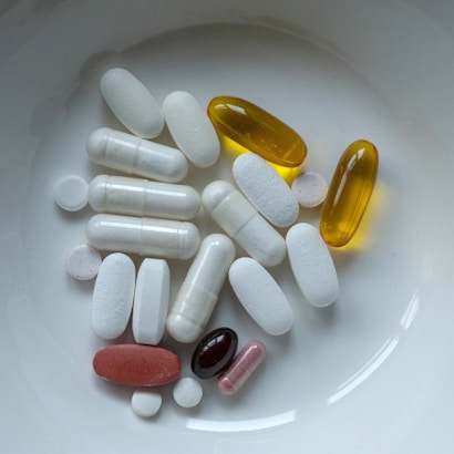 Pills and capsules are inside a white bowl.