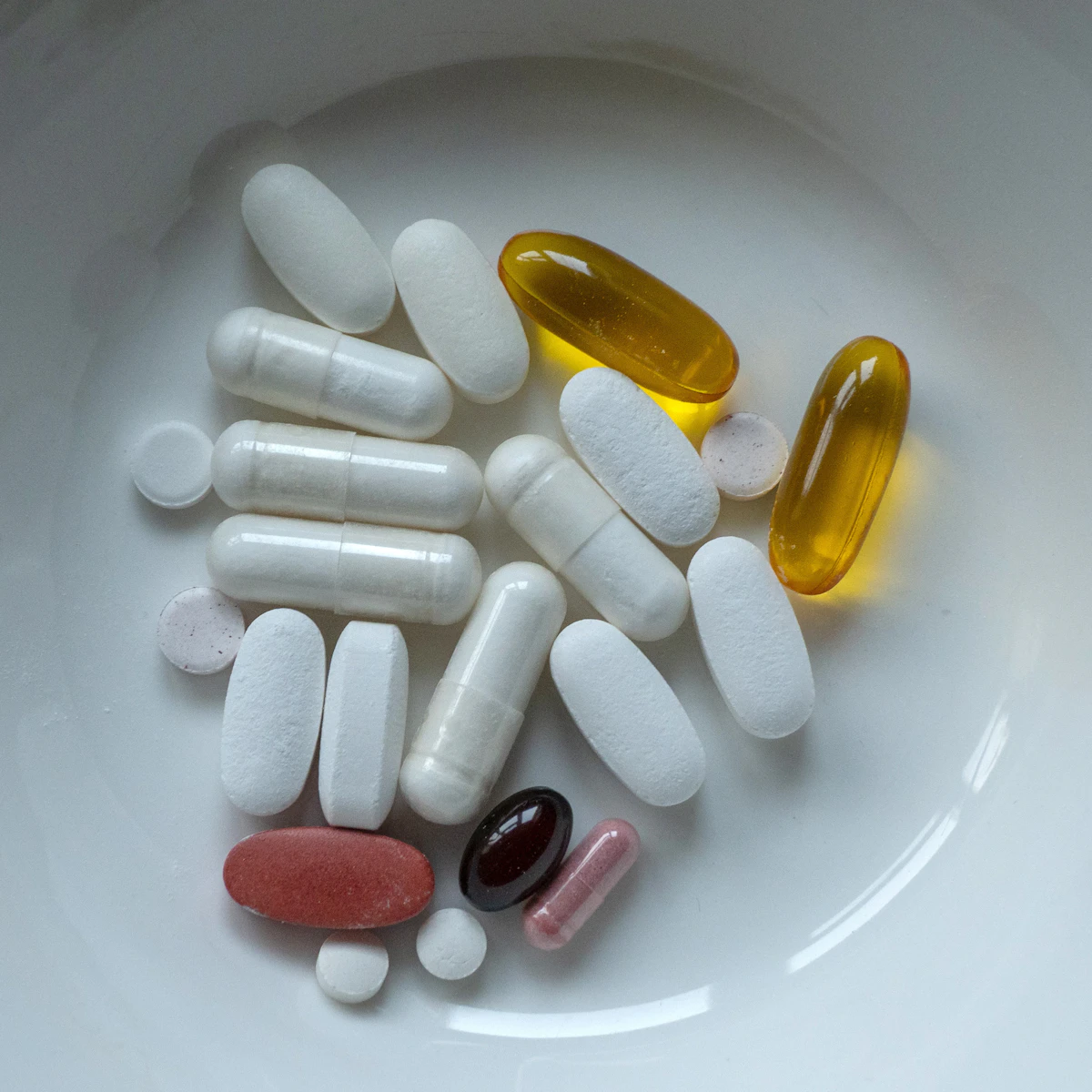 Various capsules and supplements in a bowl