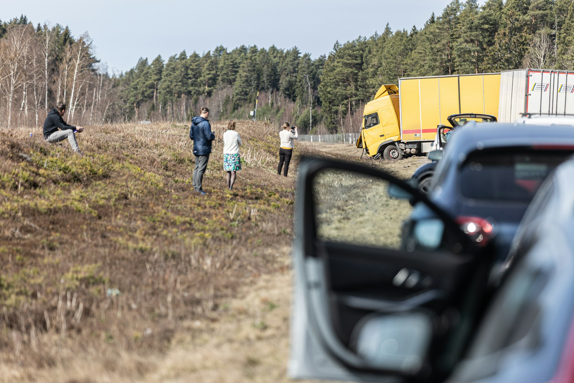 People investigate an accident near the roadside.