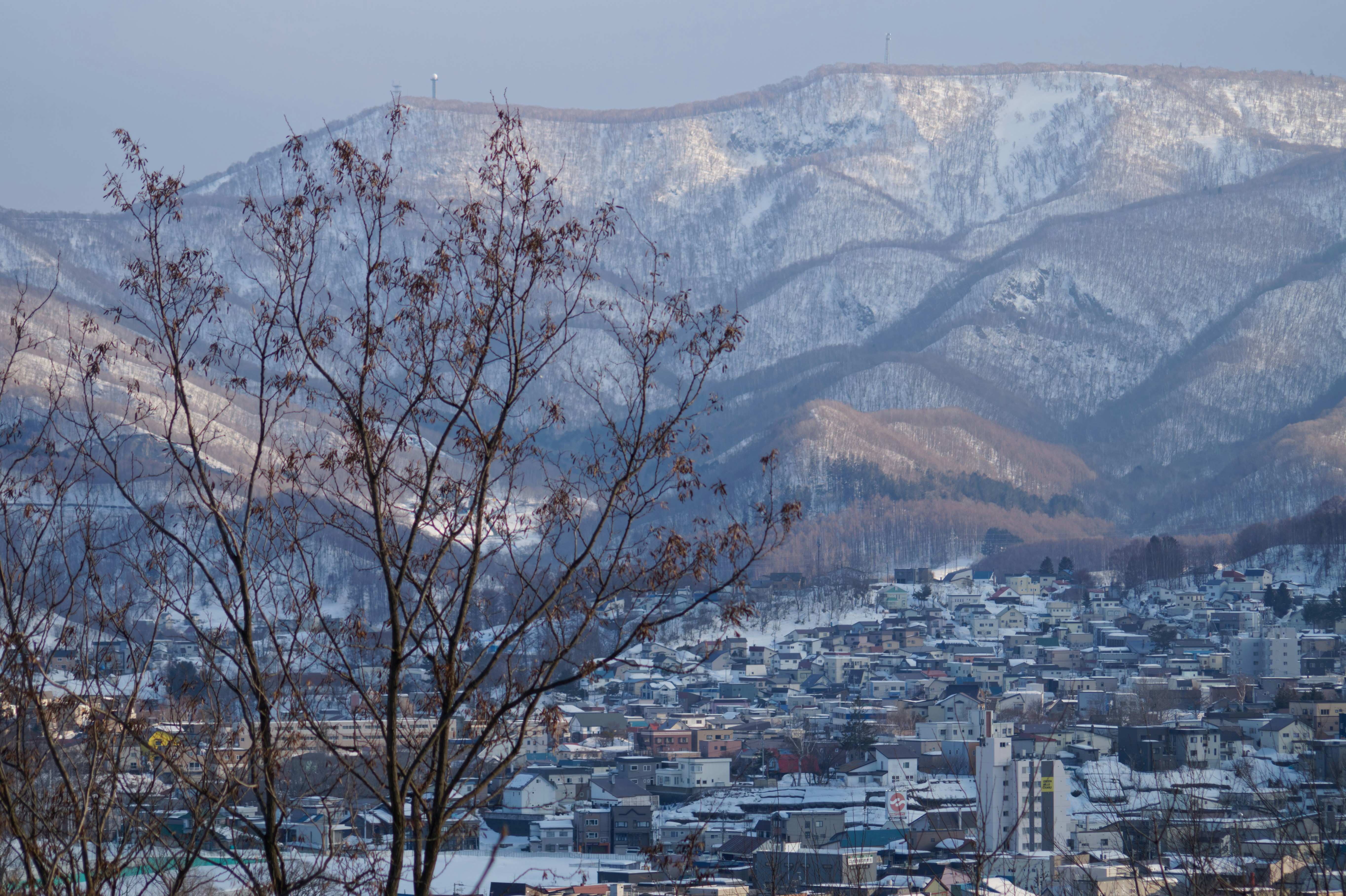 Snow-covered mountains loom over a town in winter.